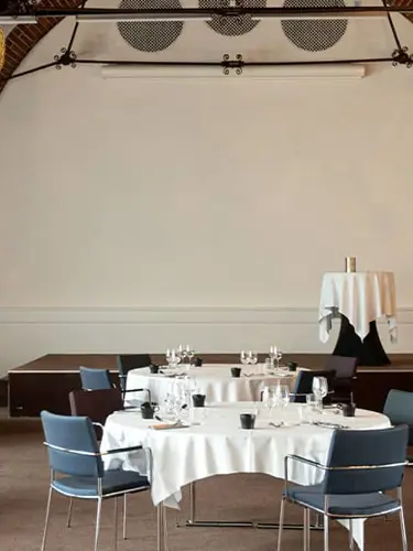 The dining room Mimersalen with large windows and set tables