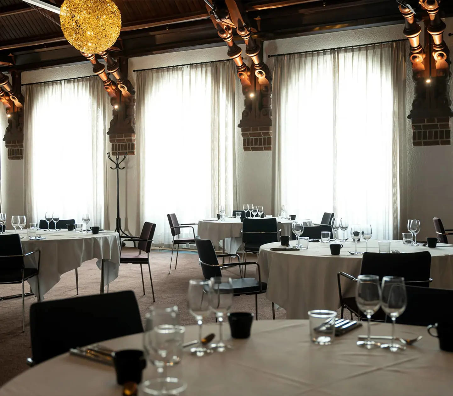 The dining room Mimersalen with large windows and set tables