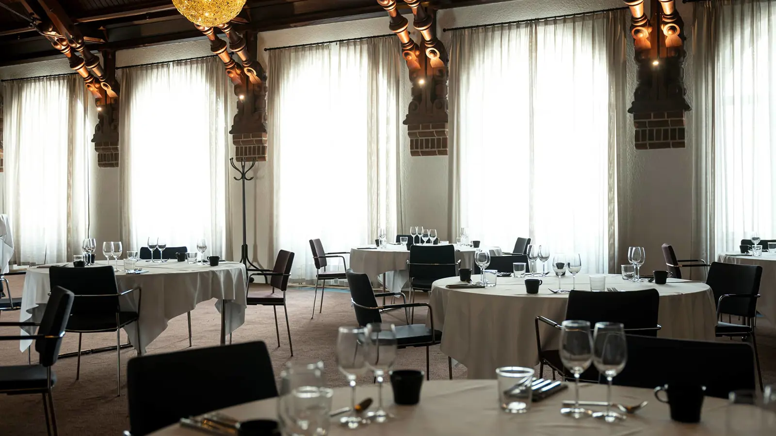 The dining room Mimersalen with large windows and set tables