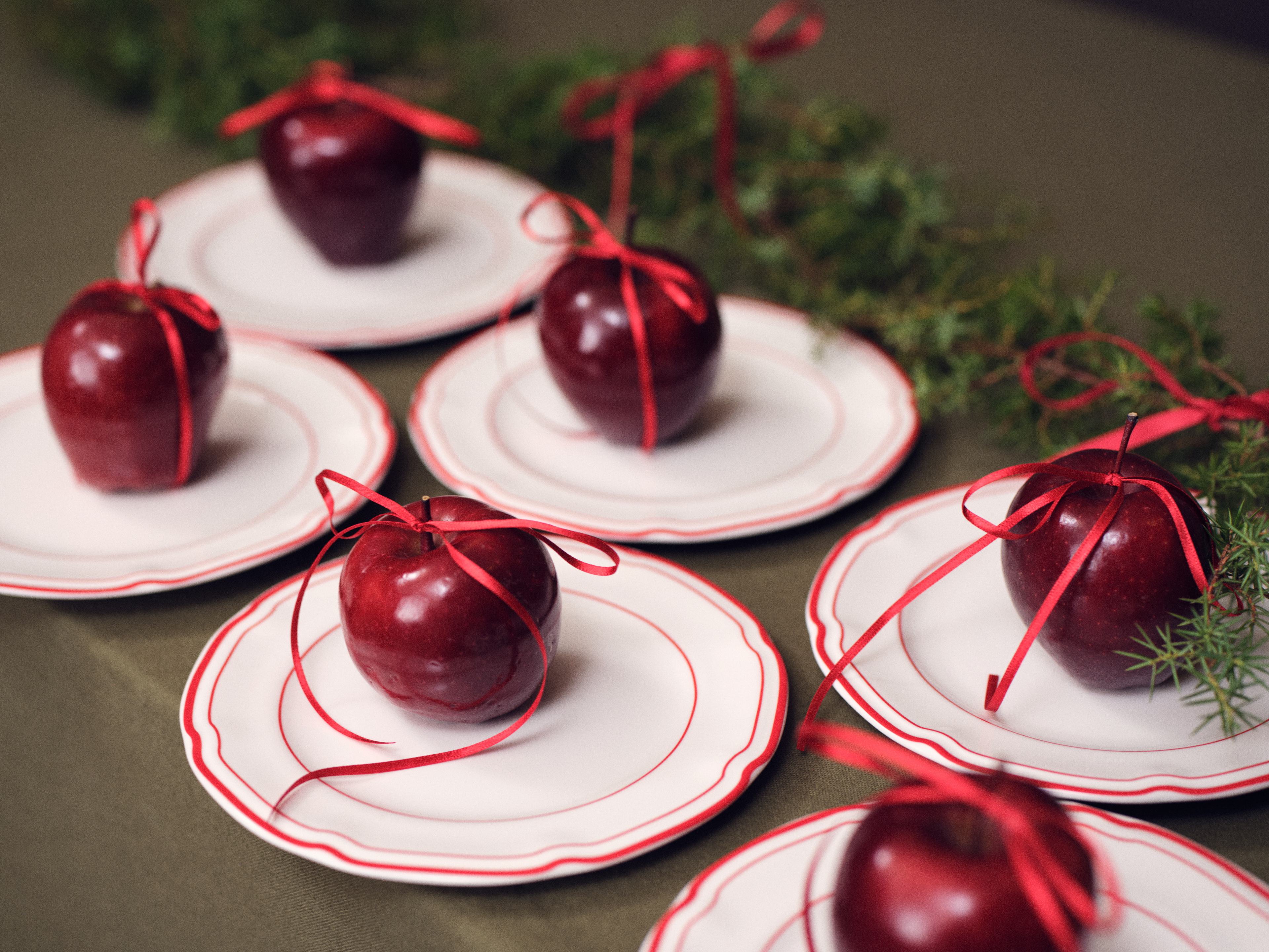 Röda äpplen på vita tallrikar