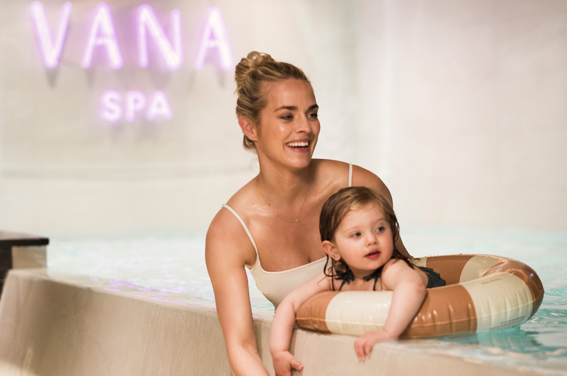 Mamma och dotter i en pool med badring