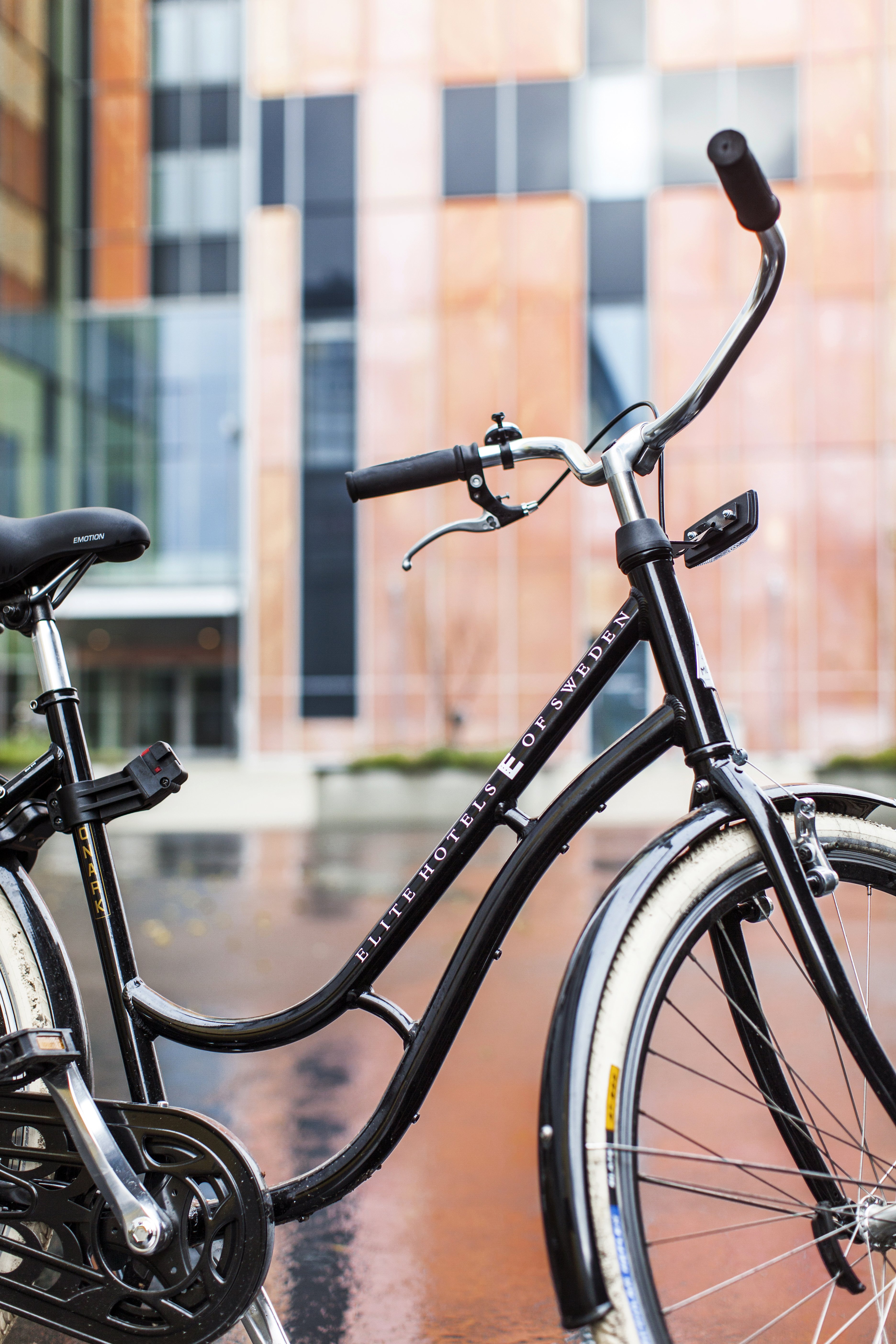 Black bike with Elite print in front of hotel facade