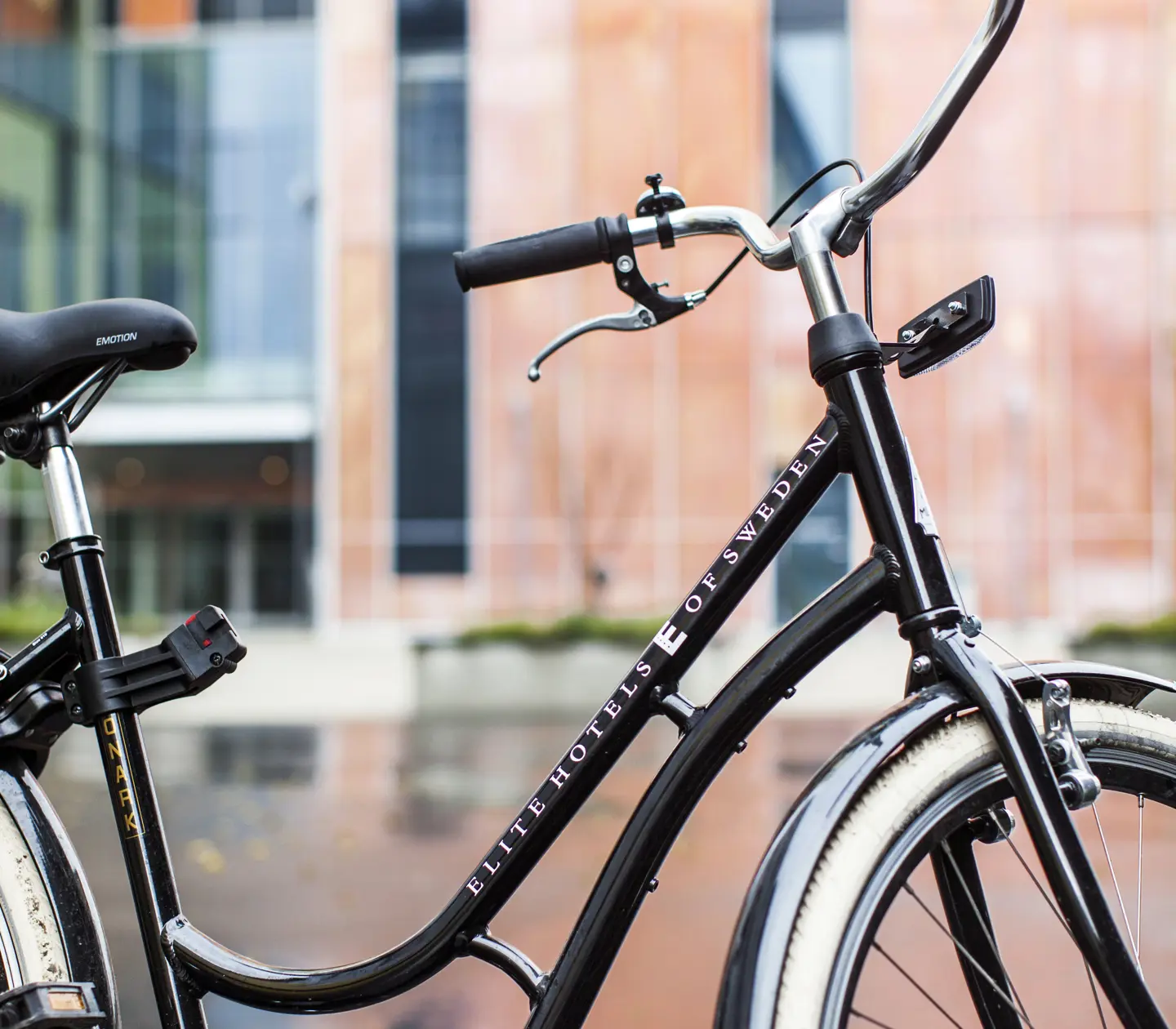 Black bike with Elite print in front of hotel facade