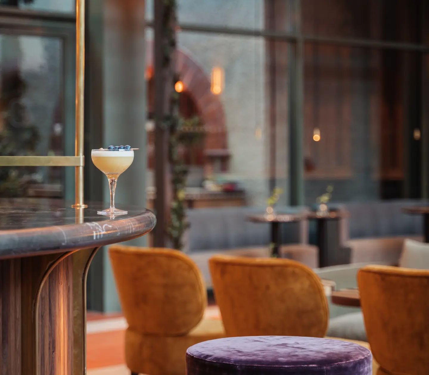 Bar environment with a light drink on the counter and orange chairs in the background