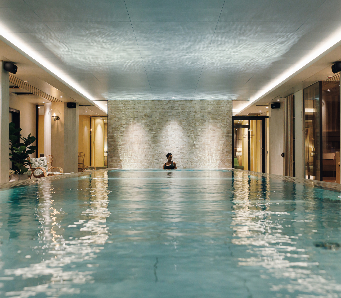 Spa environment with pool, sunbeds and woman in the water
