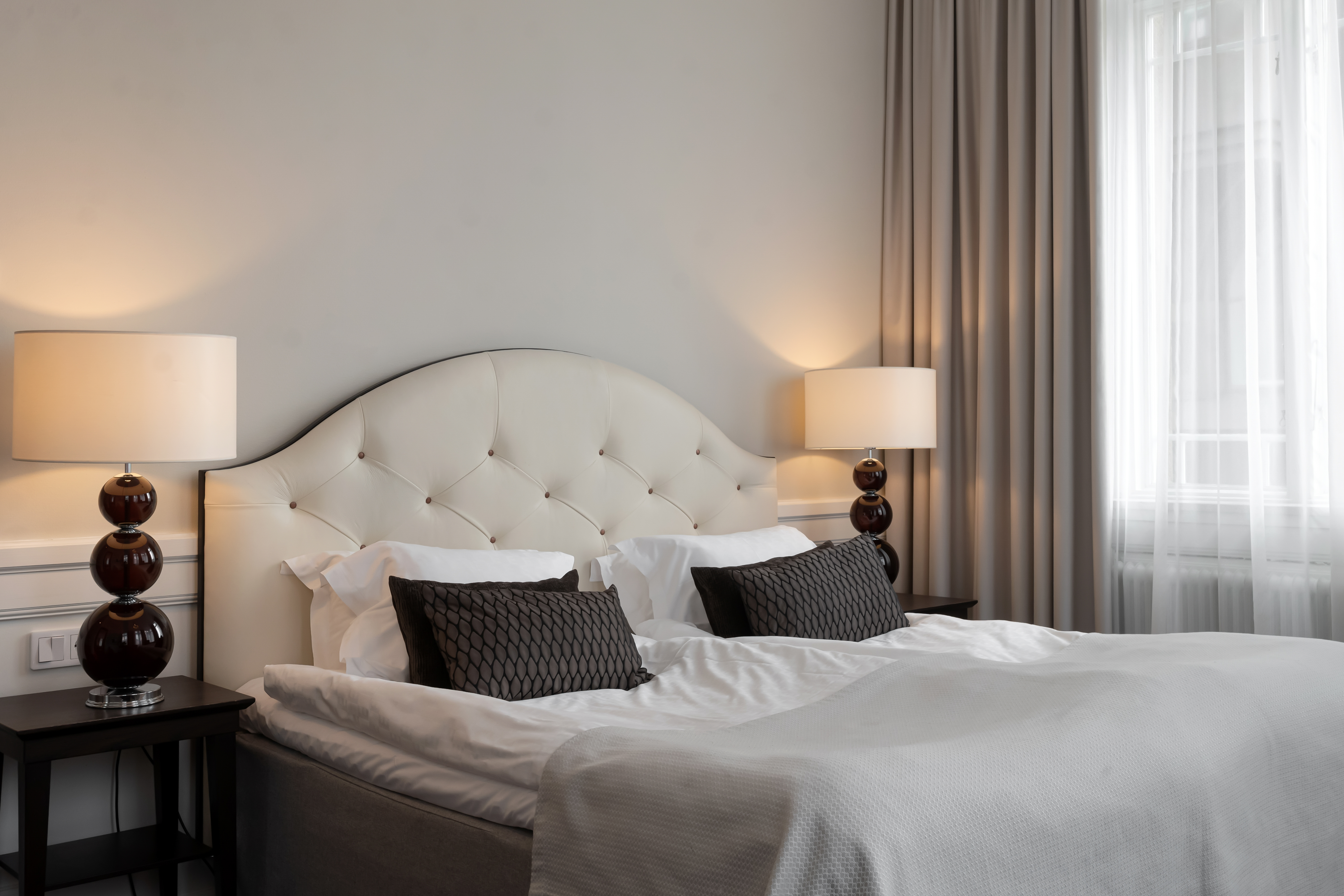 Ljus svit med säng, sänglampor och fönster