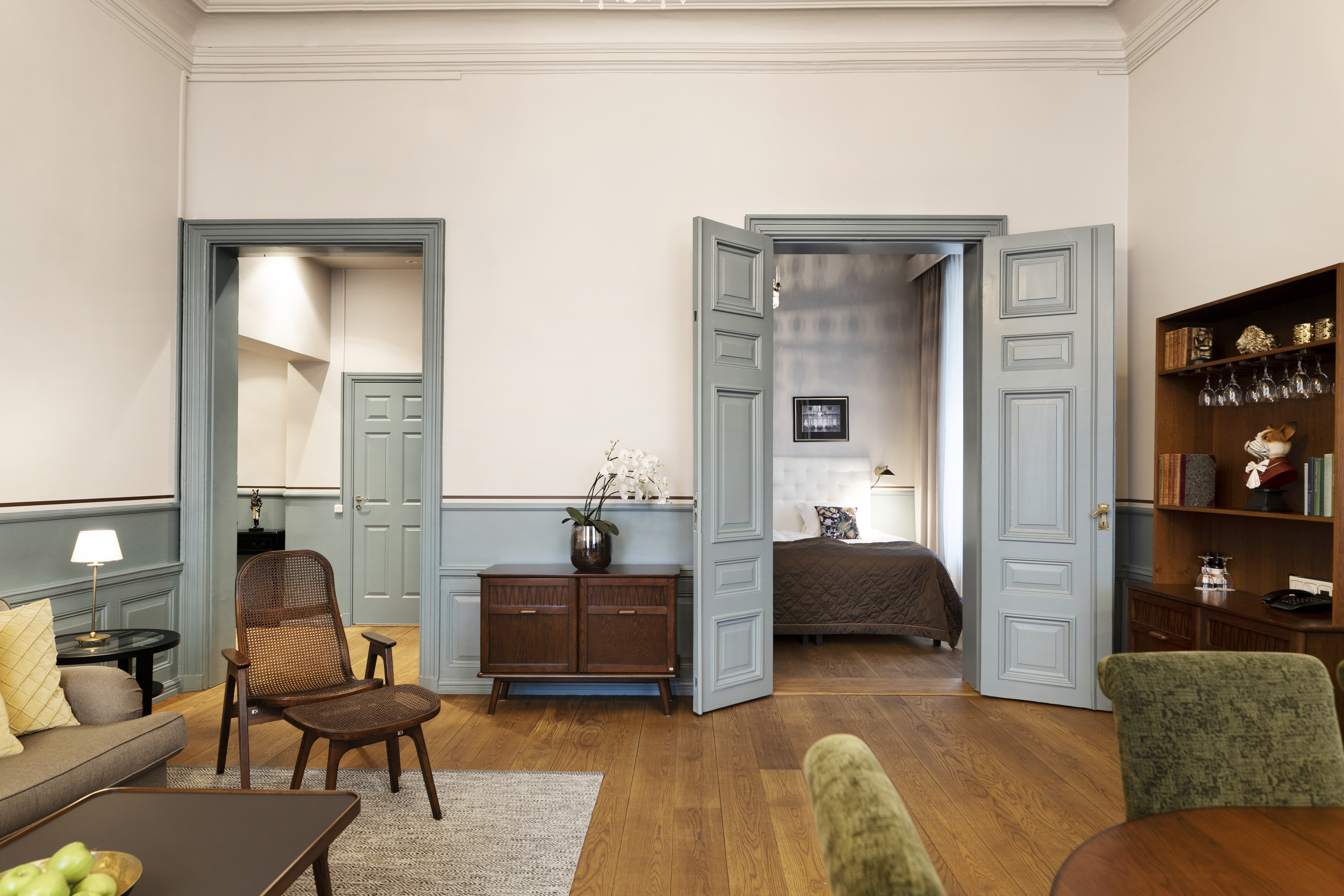 Svit med säng, soffa och gröna detaljer