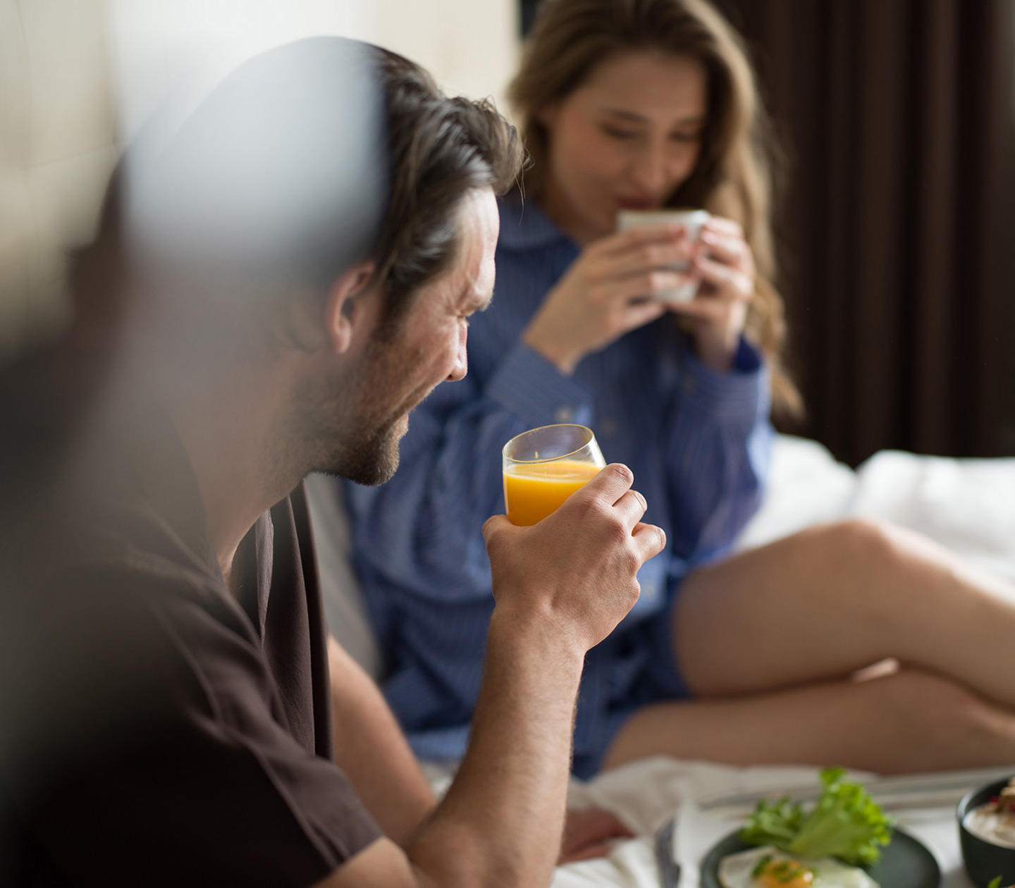A couple having breakfast in a hotel bed