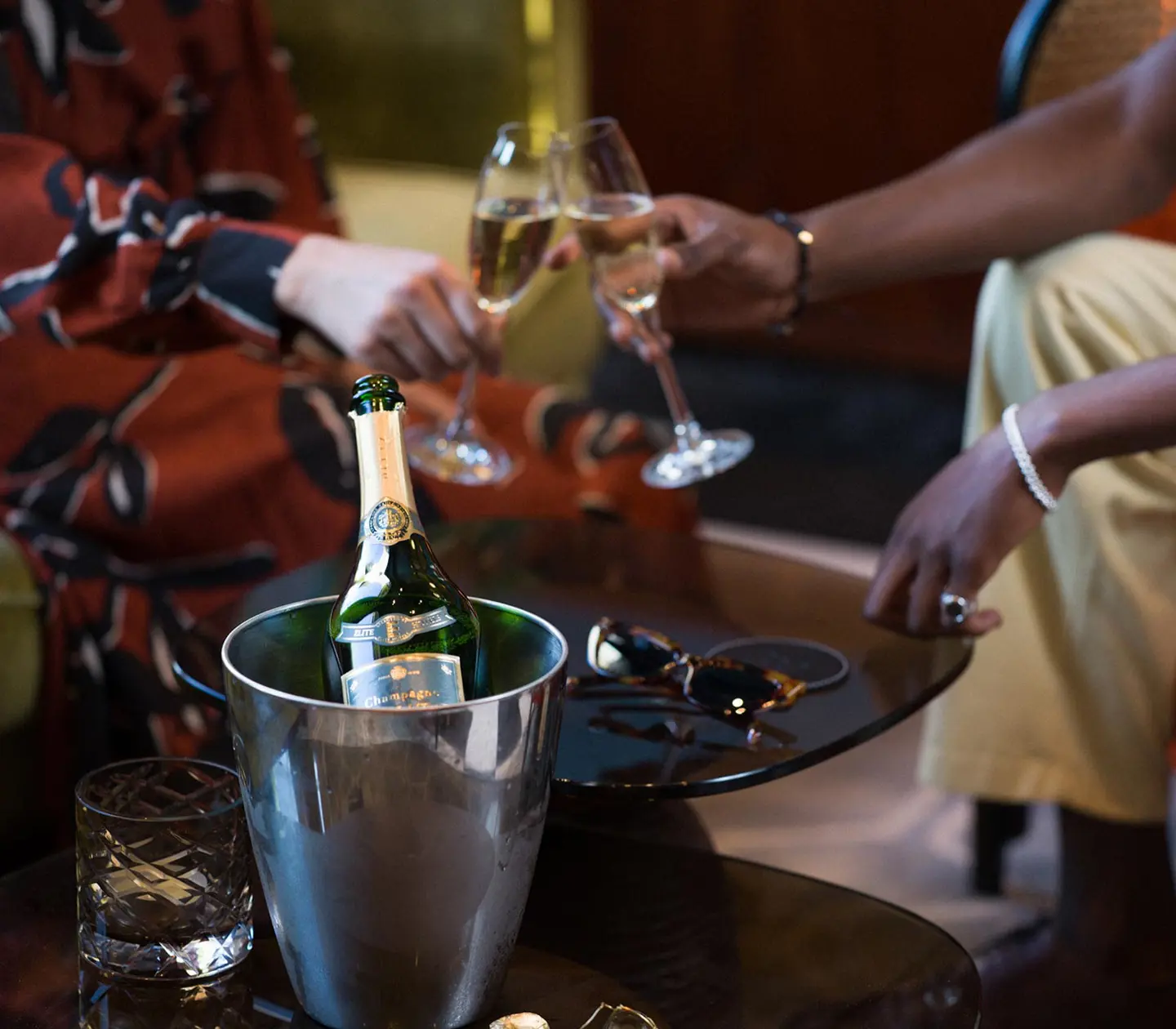 Par som skålar i Champagne och en flaska Deutz står i förgrunden