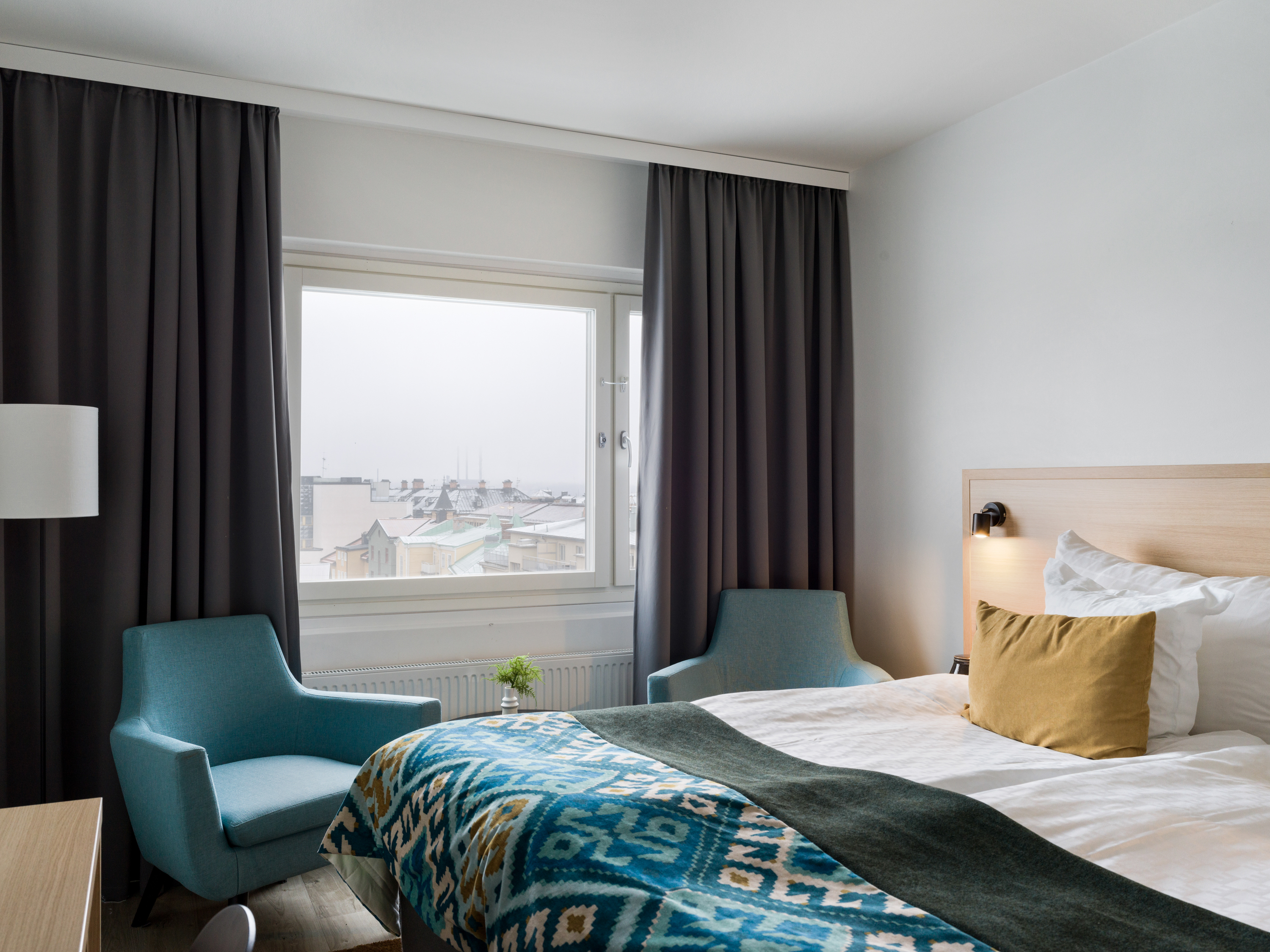 Ett hotellrum med en dubbelsäng och skrivbord