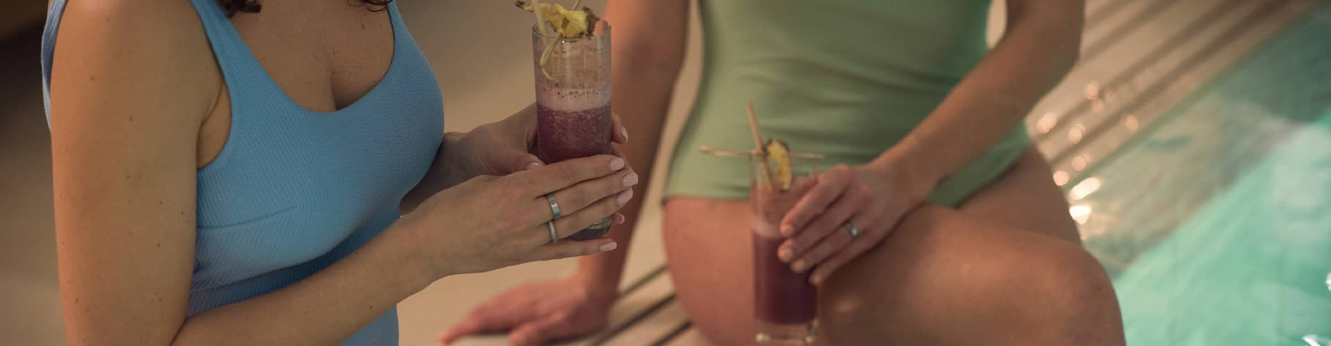 Two guests drinking smoothies by the pool