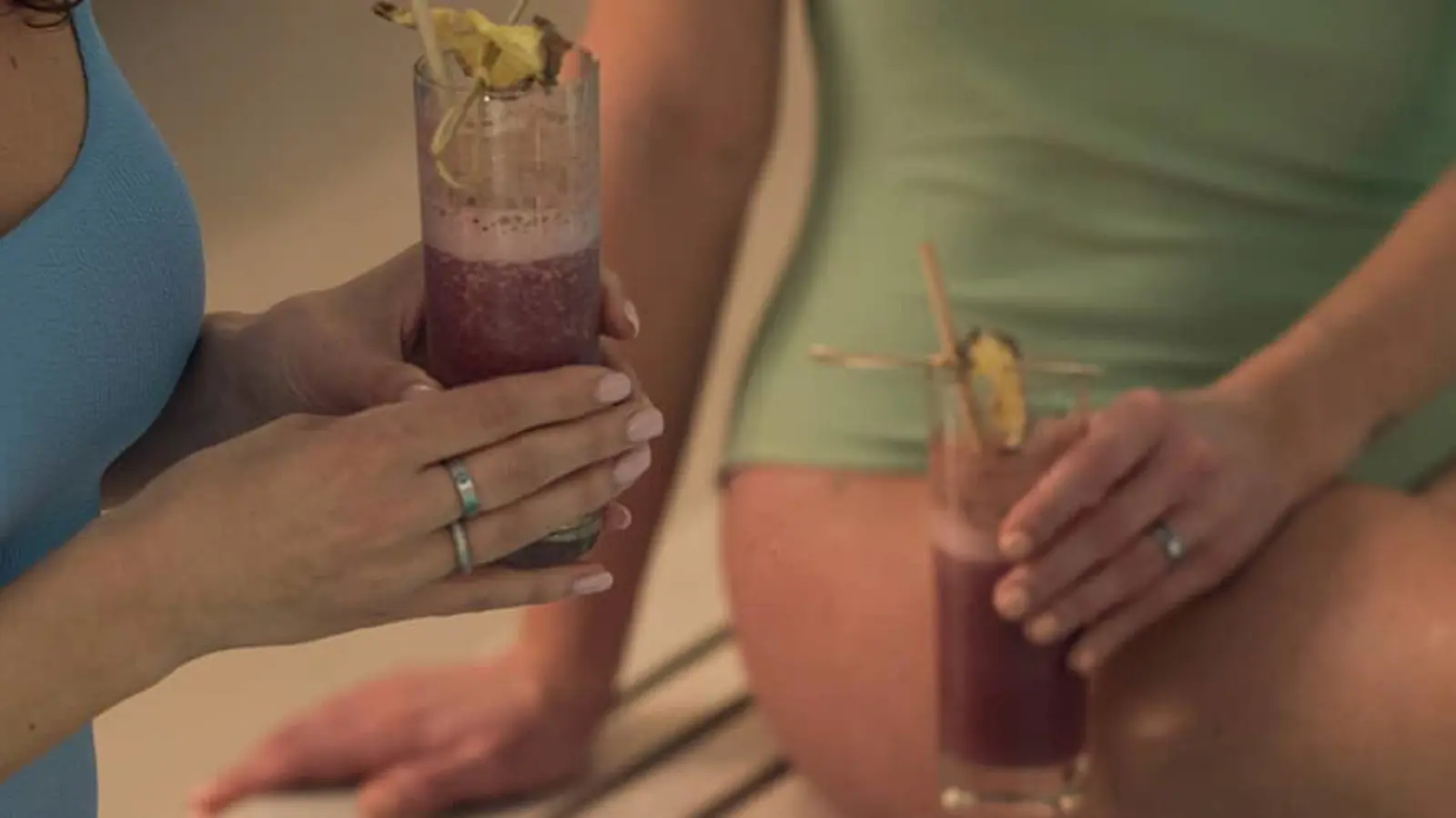 Two guests drinking smoothies by the pool