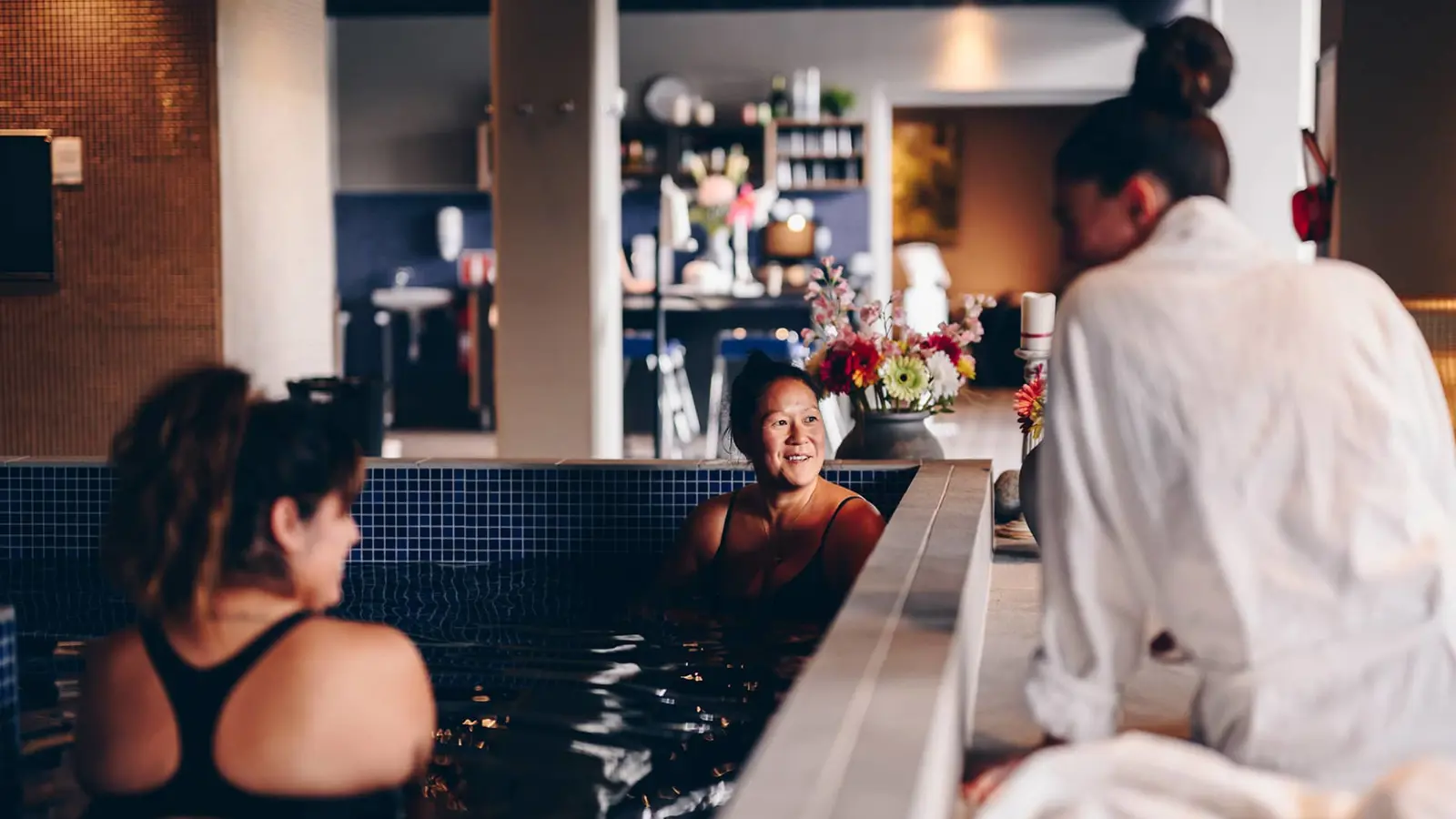 Three women hanging out in a pool at a relaxation area