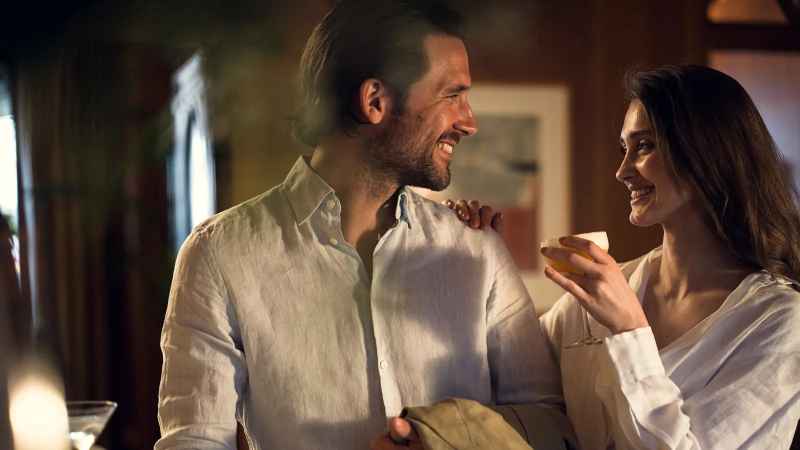 A party-dressed pair of toasts are standing in a bar