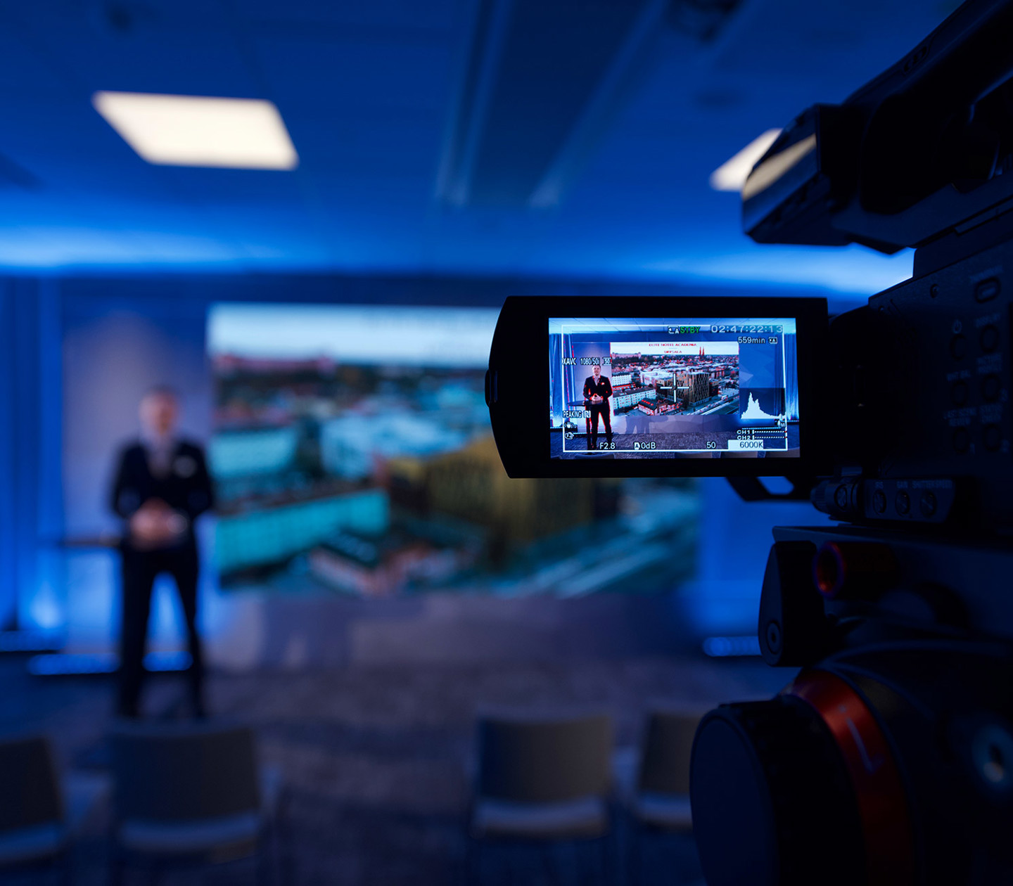 A man holding a presentation and a camera recording him