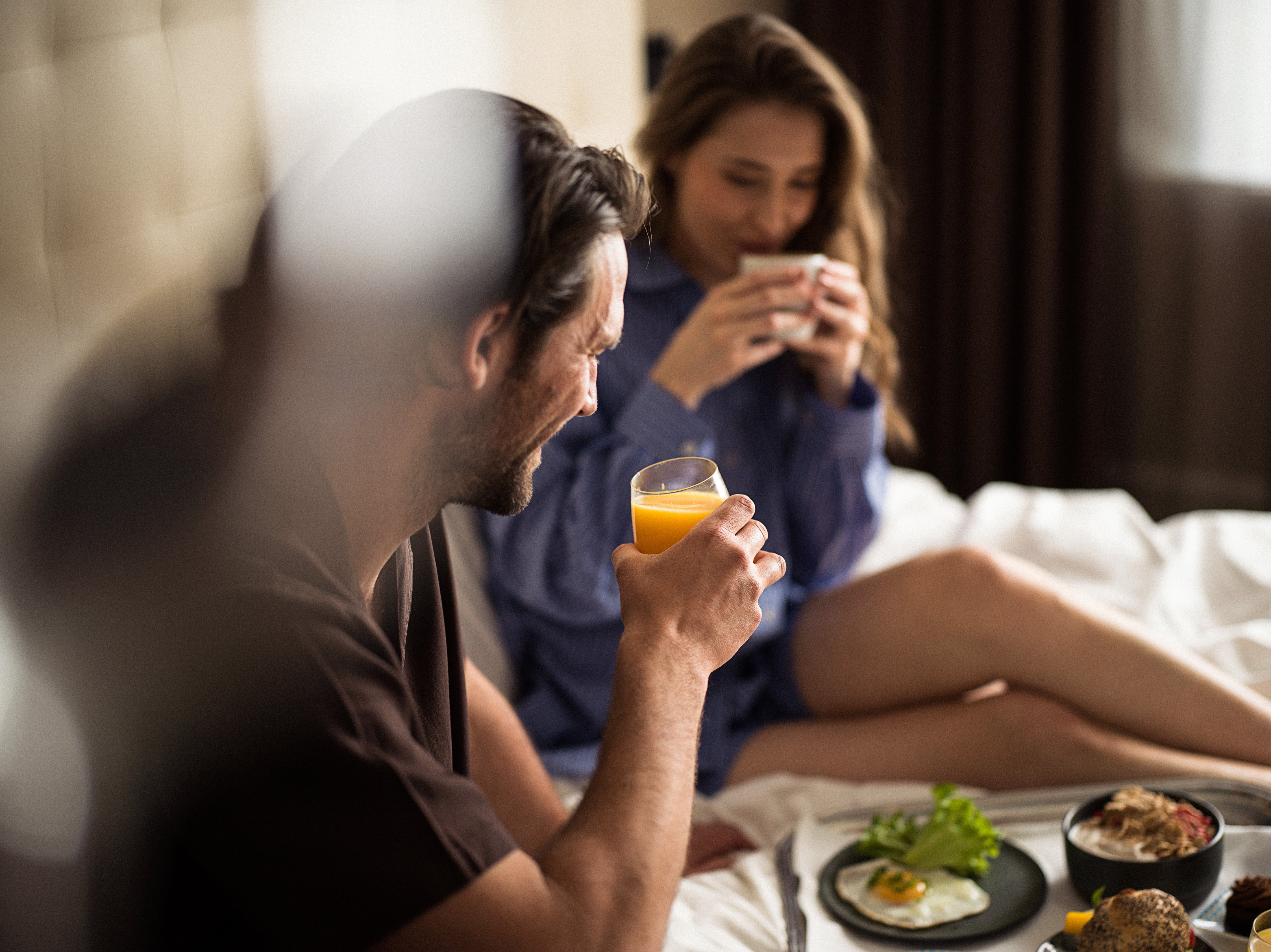 Par som äter frukost i hotellsäng