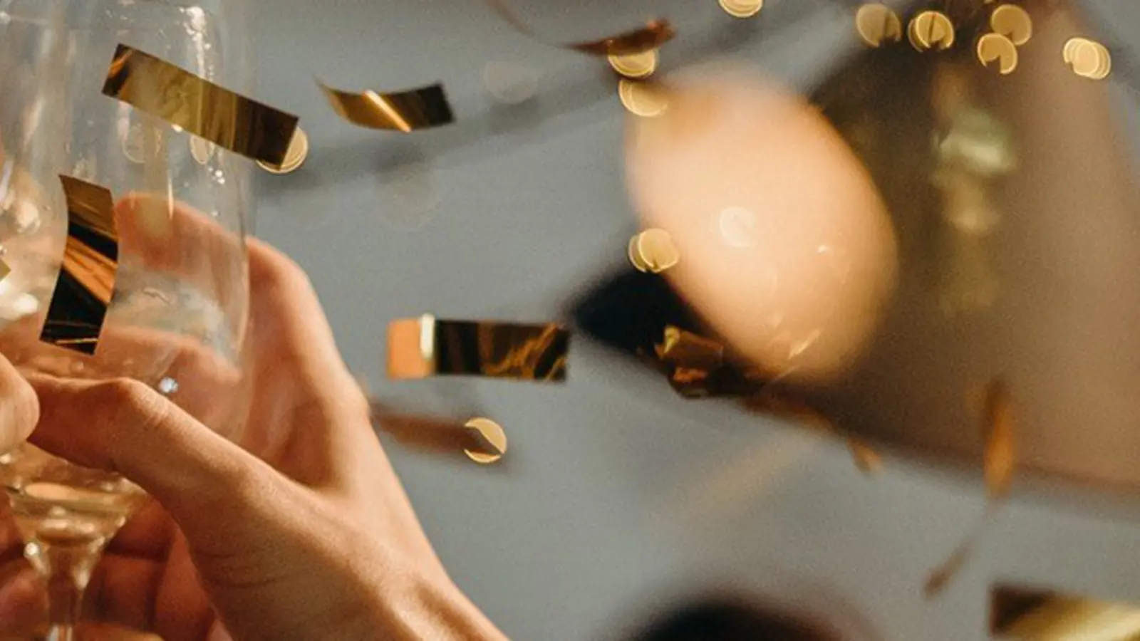 People toasting while confetti falls at a New Year's celebration