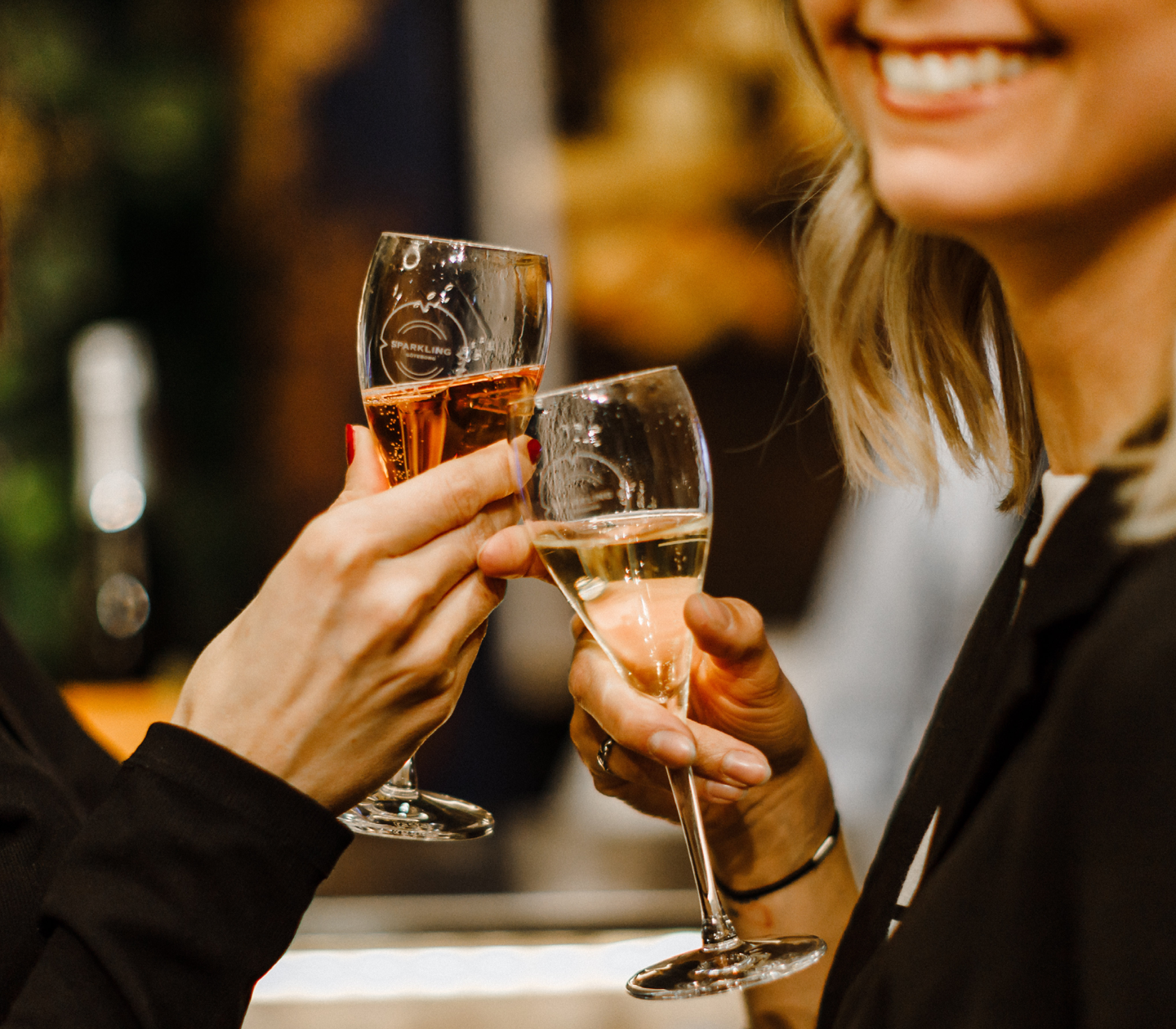 Två kvinnor skålar med champagneglas på en festlig tillställning