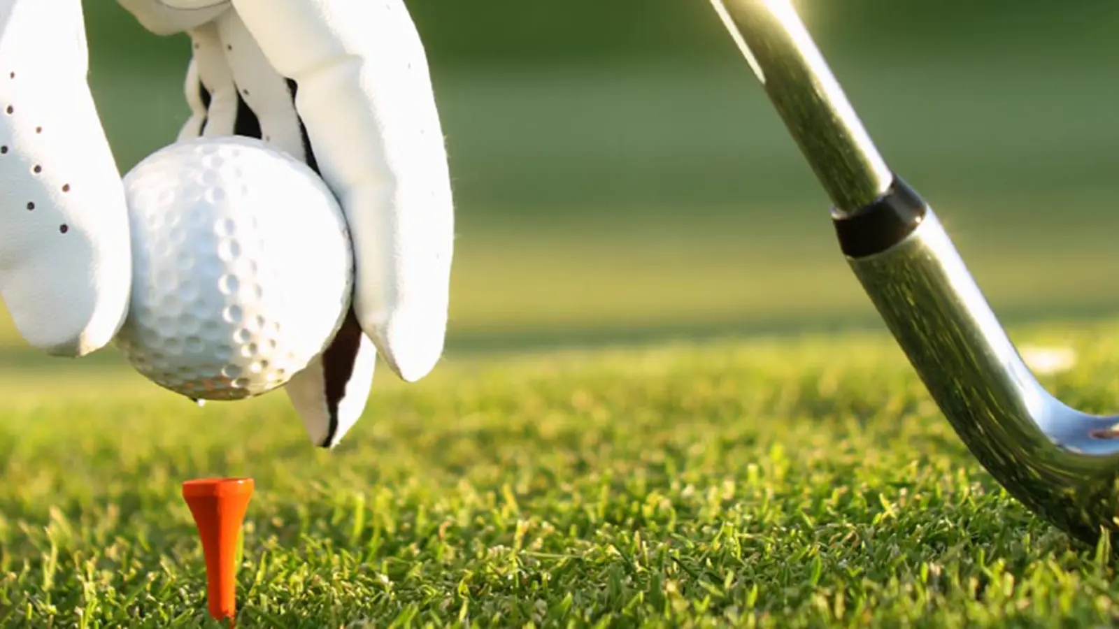 A close up of a golf ball and a golf club