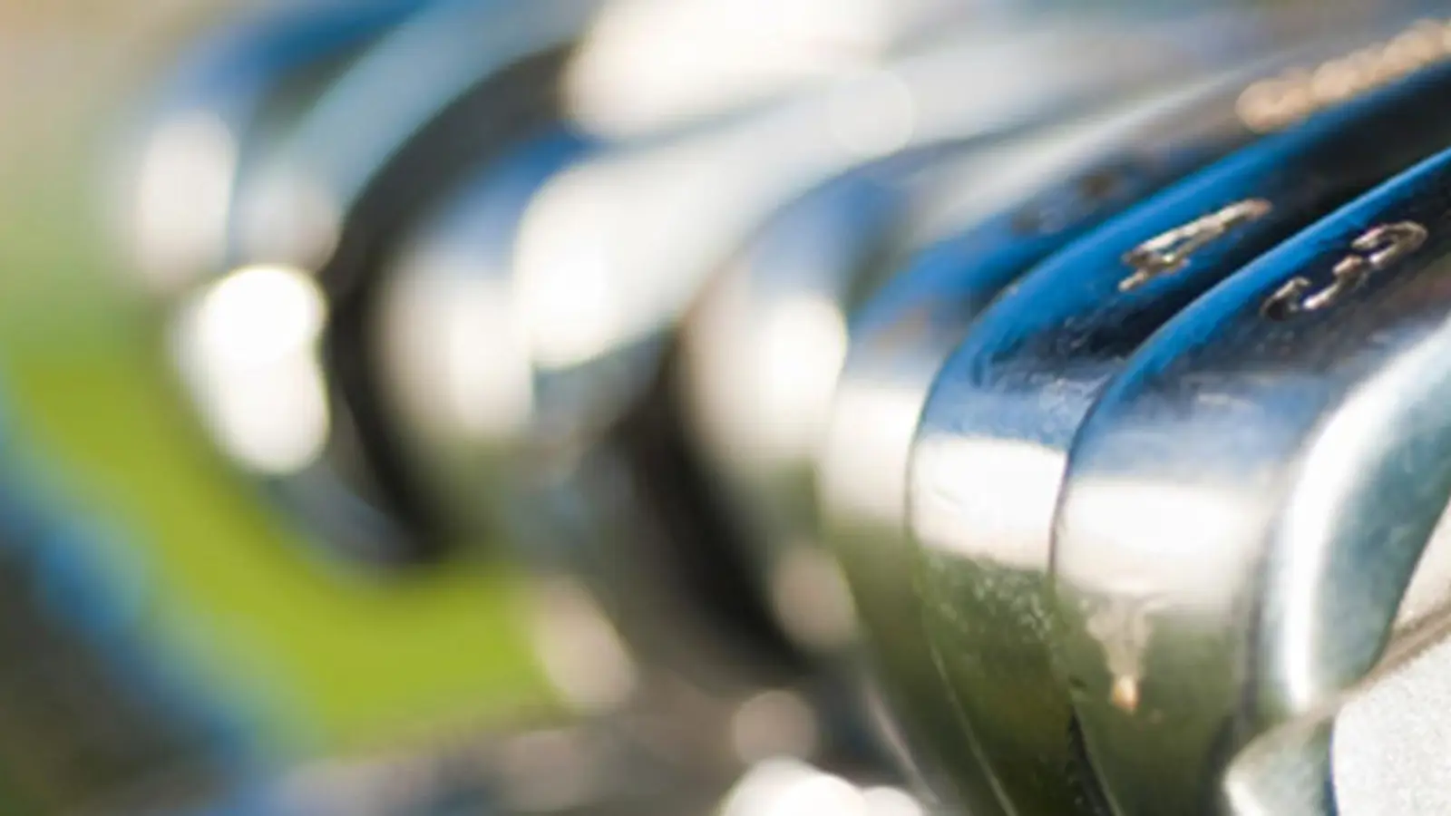 Golfklubbor med en golfbana i bakgrunden