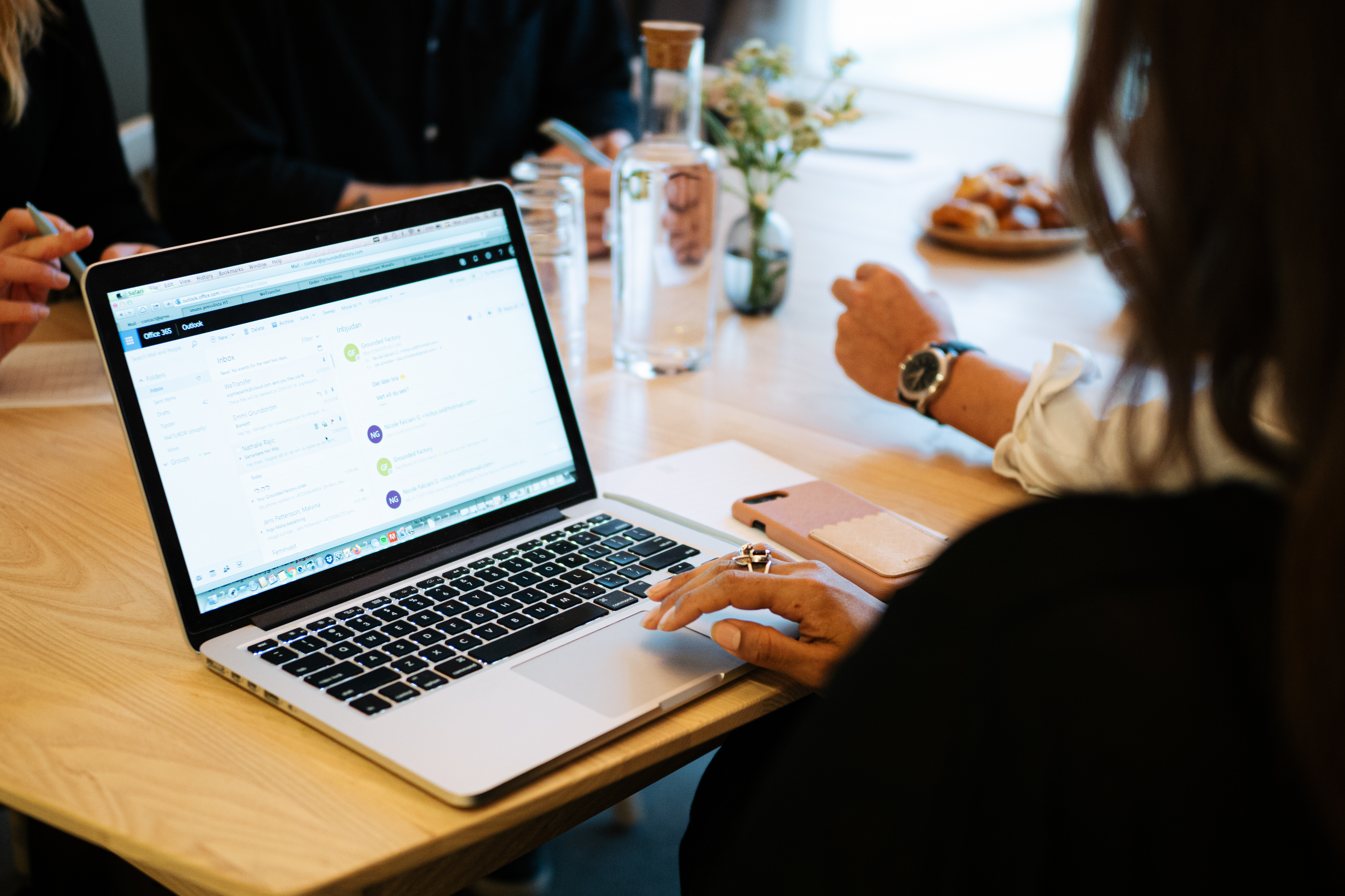 Kvinna som sitter med sin dator vid ett konferensbord