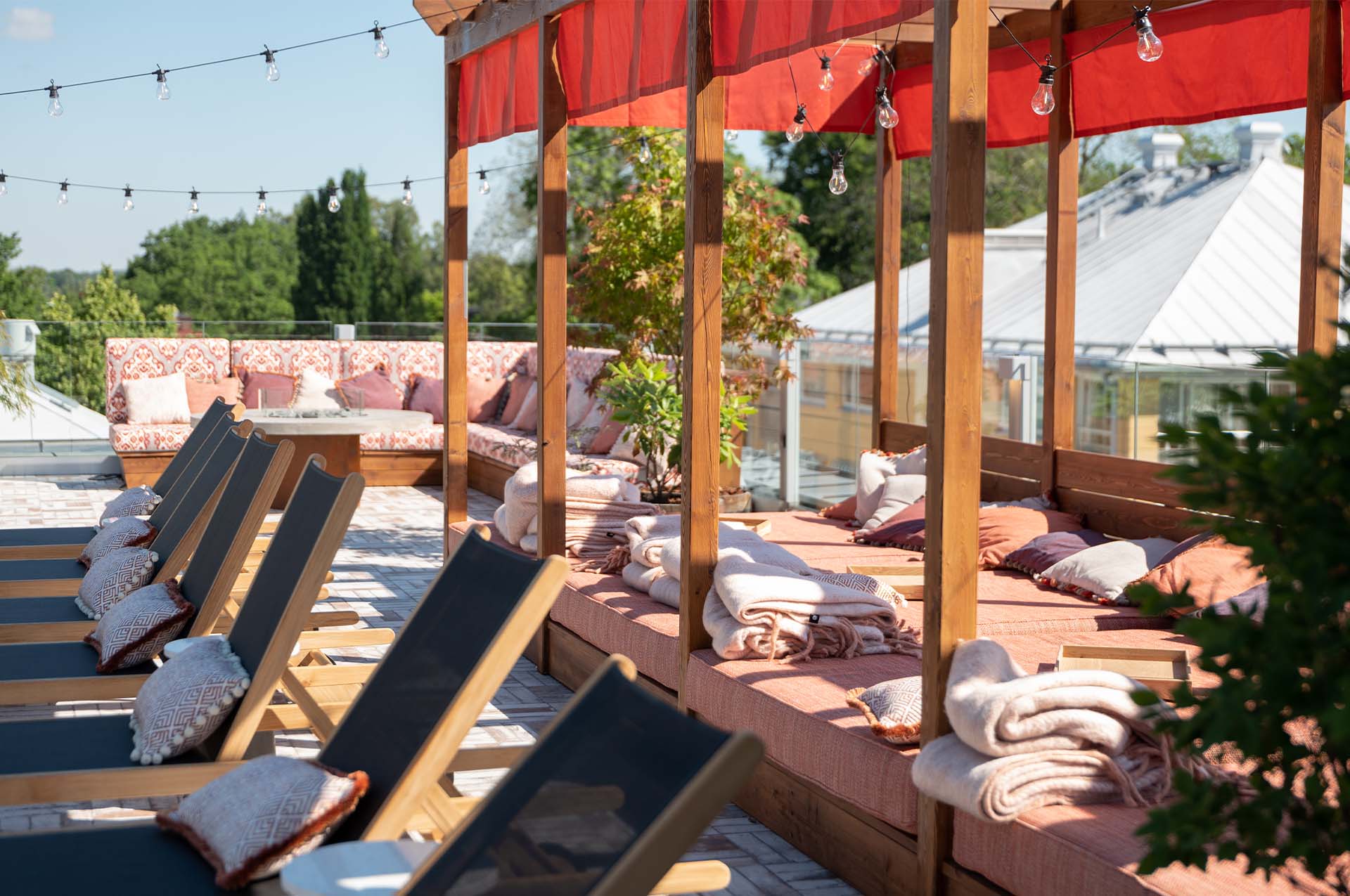 Solsängar på rad på ett soligt Rooftop by Vana