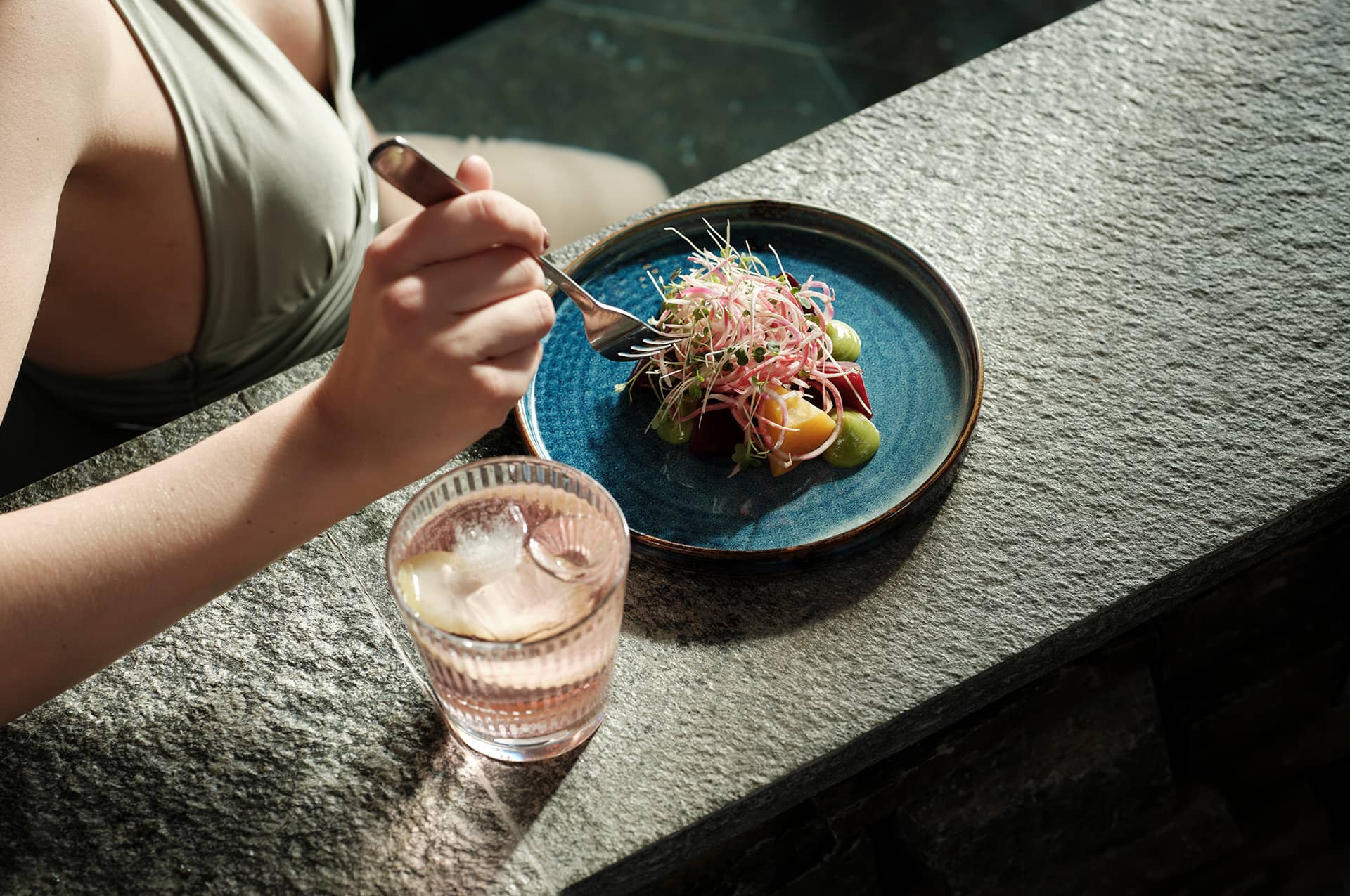Woman eating and drinking lying in a pool