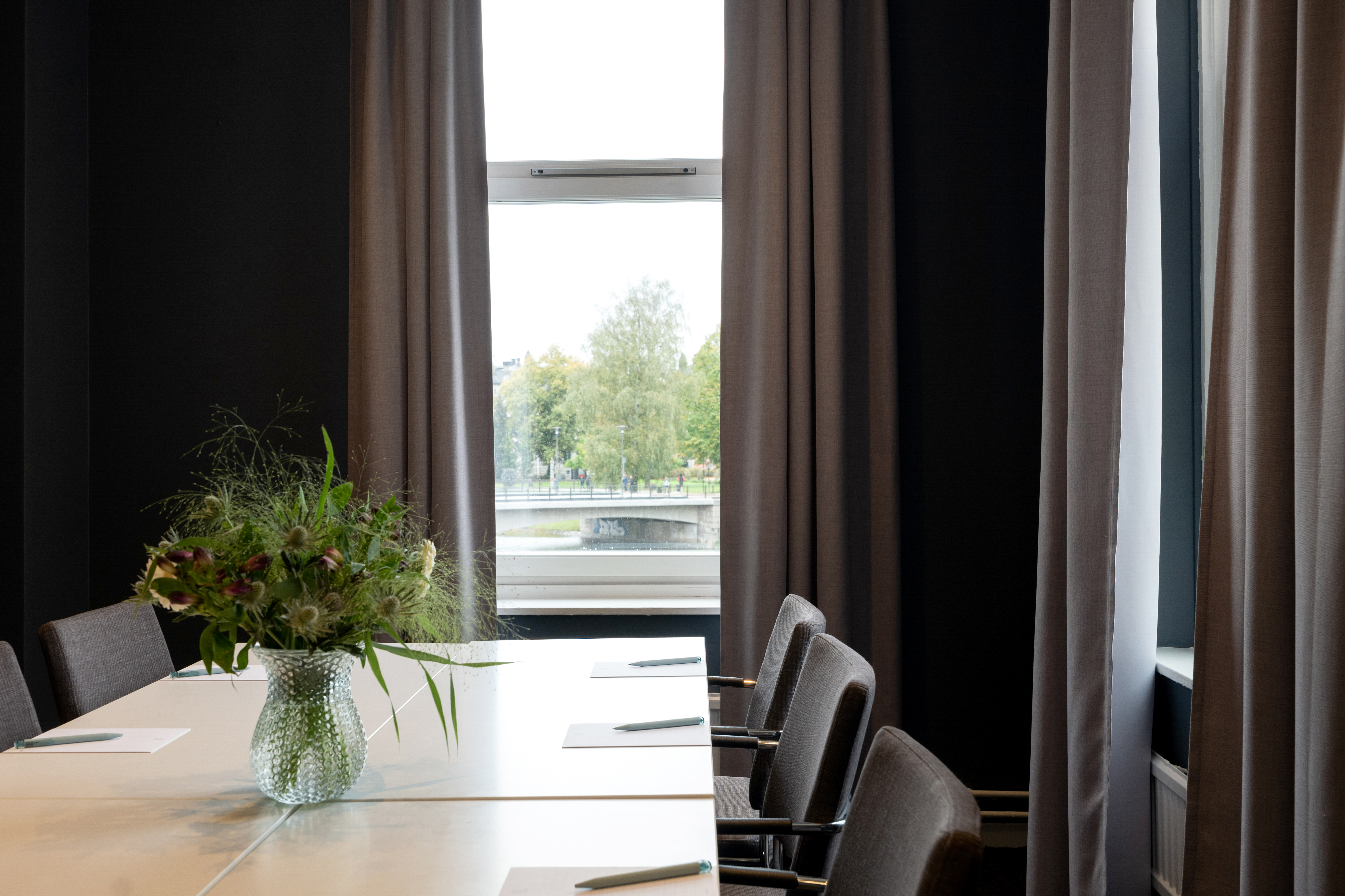 Konferenslokal med blombukett på bordet och fin utsikt.