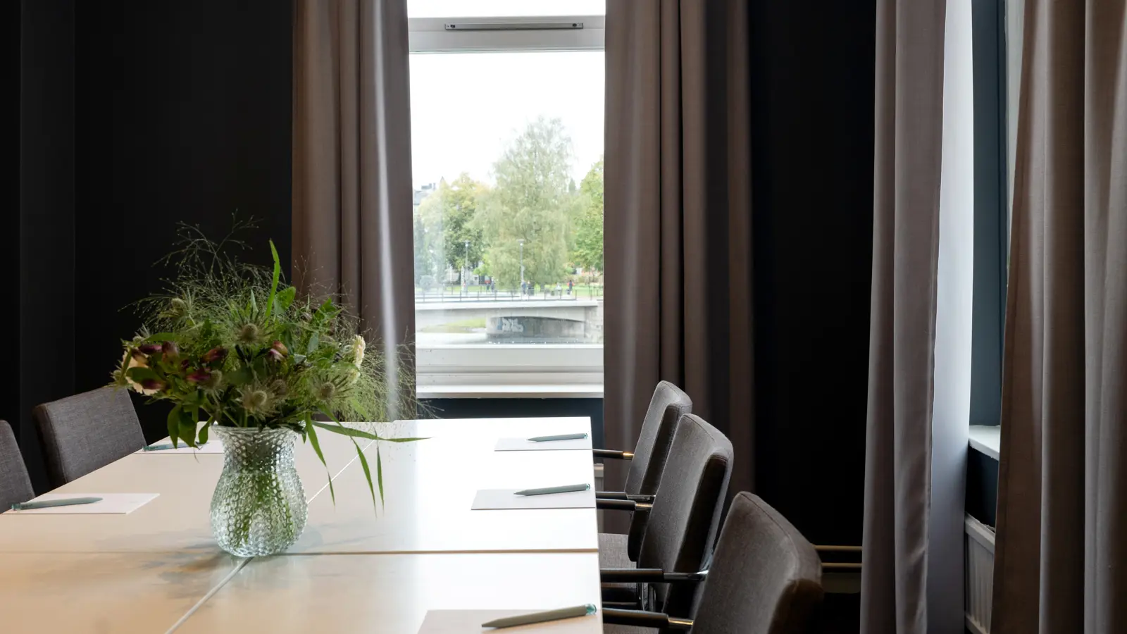 Konferenslokal med blombukett på bordet och fin utsikt.