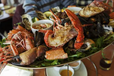 Lyxig skaldjurstallrik med hummer, räkor, ostron och musslor på restaurang