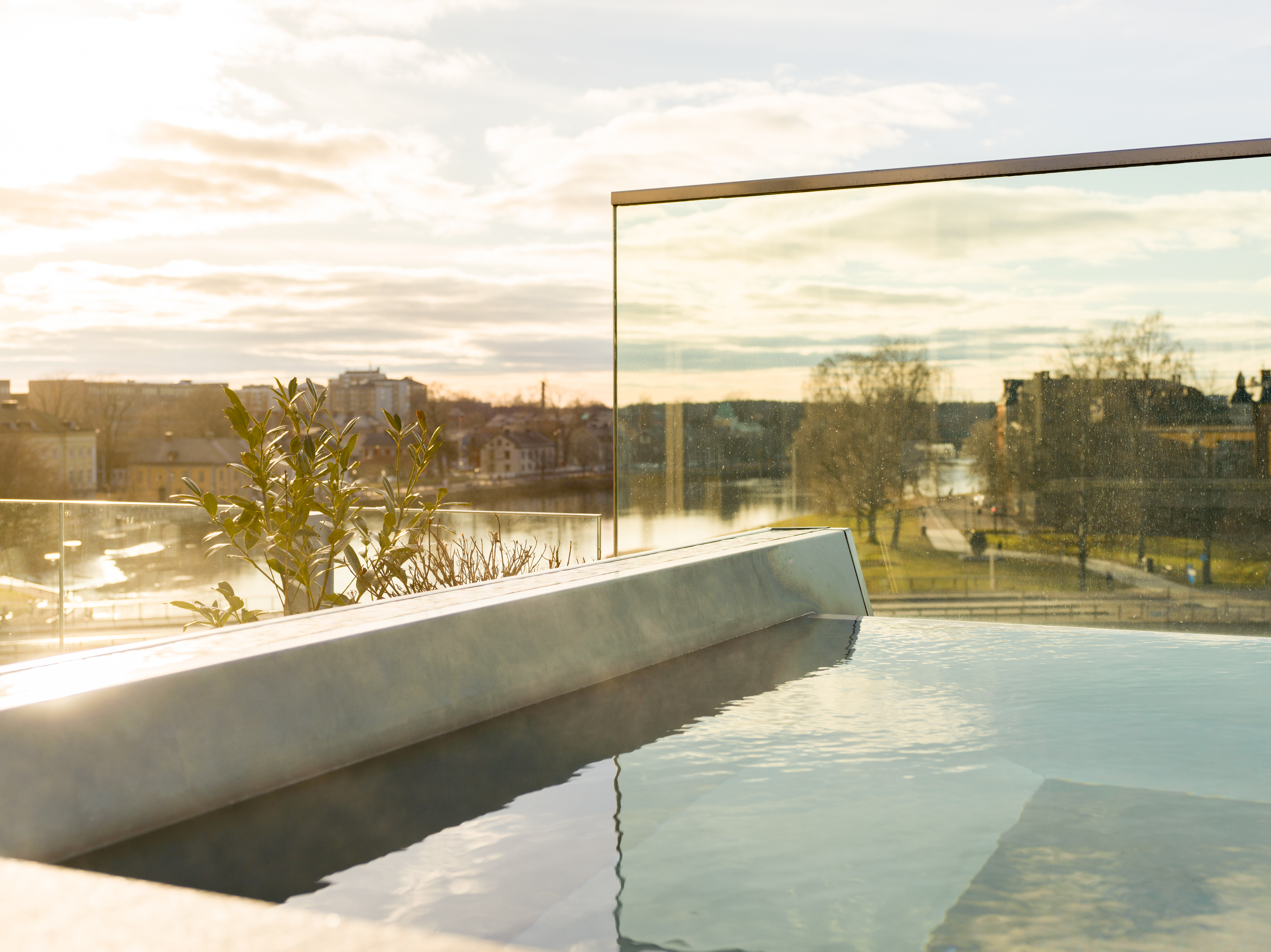Rooftop pool with view of river at sunset