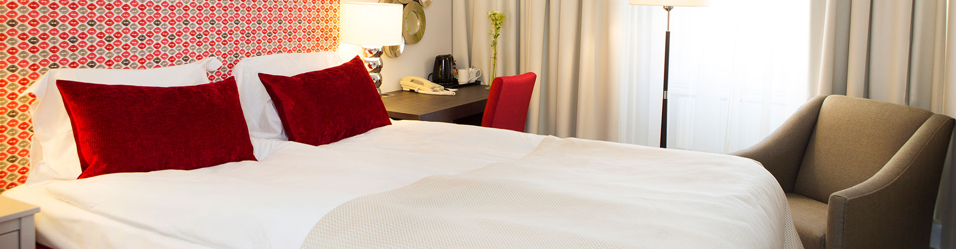 Ett dubbelrum med en fåtölj och ett litet skrivbord