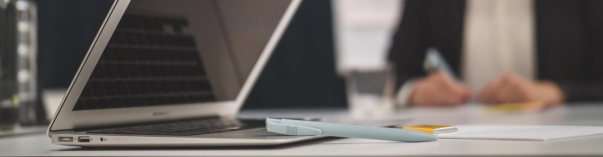 A laptop and pen lying on a conference table