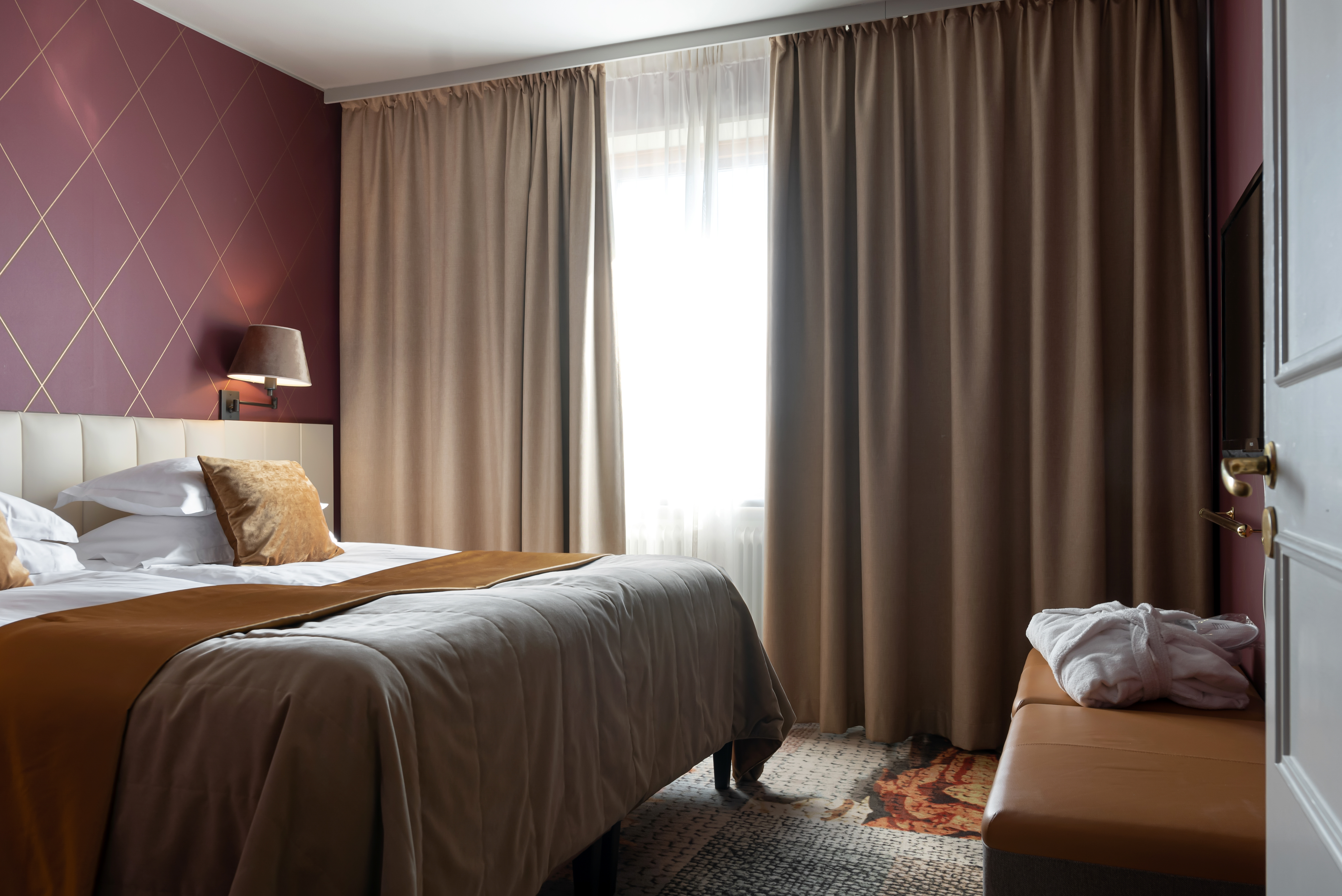 A hotel room with a double bed and a desk