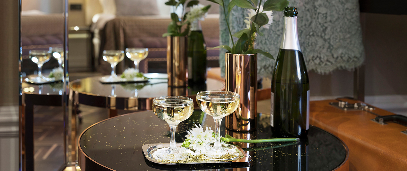 Bricka med Champagne framför en säng i ett hotellrum