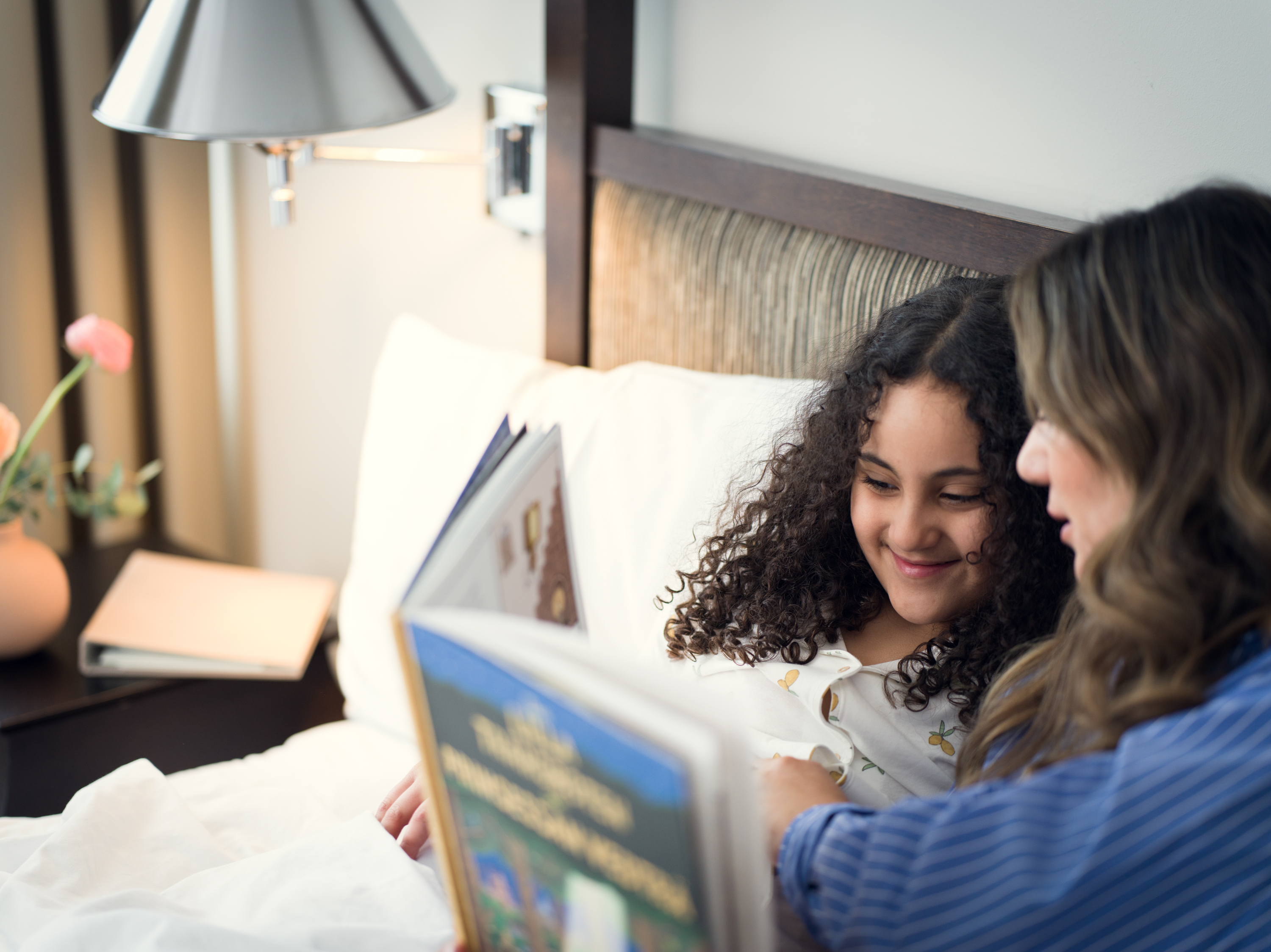 A family together on a hotel bed, all wearing bathrobes