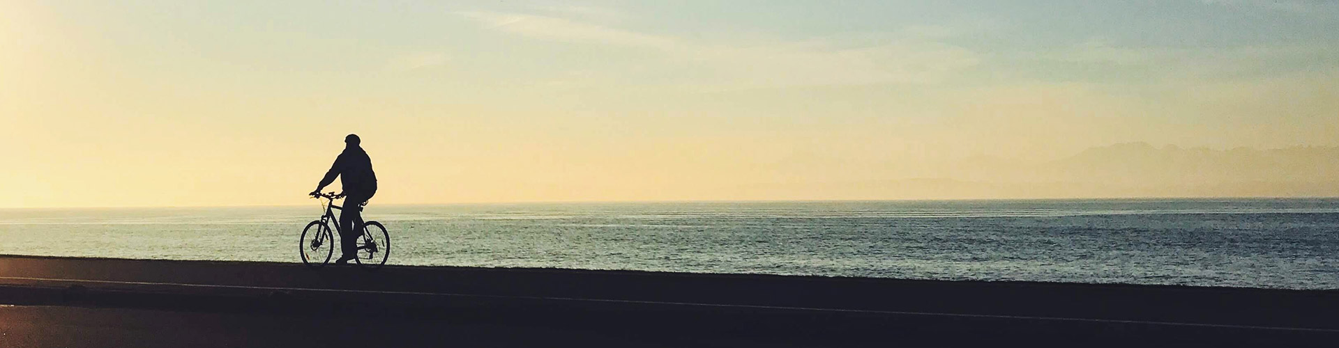 Person som cyklar längs med havet