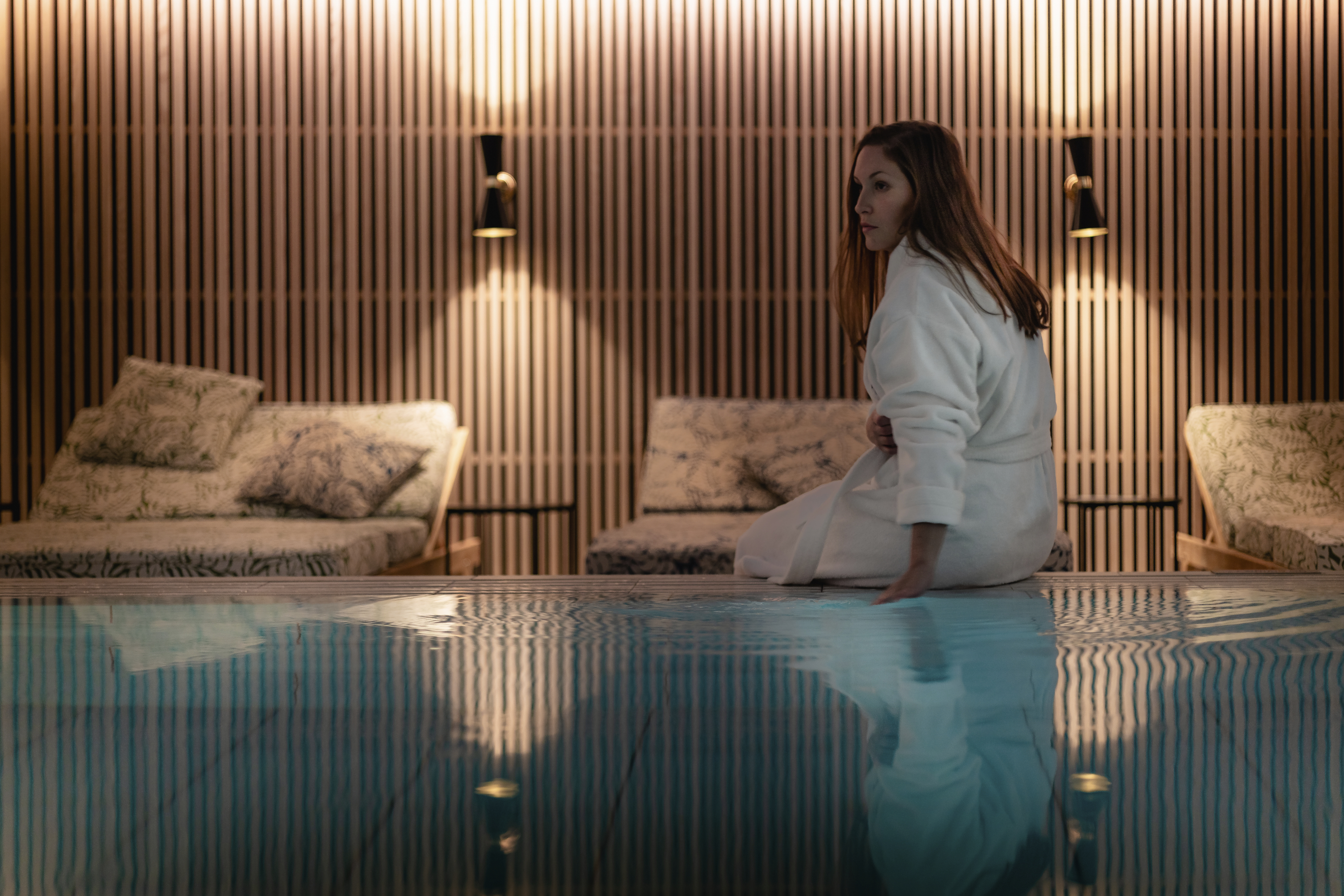 Woman sitting on the edge of a pool
