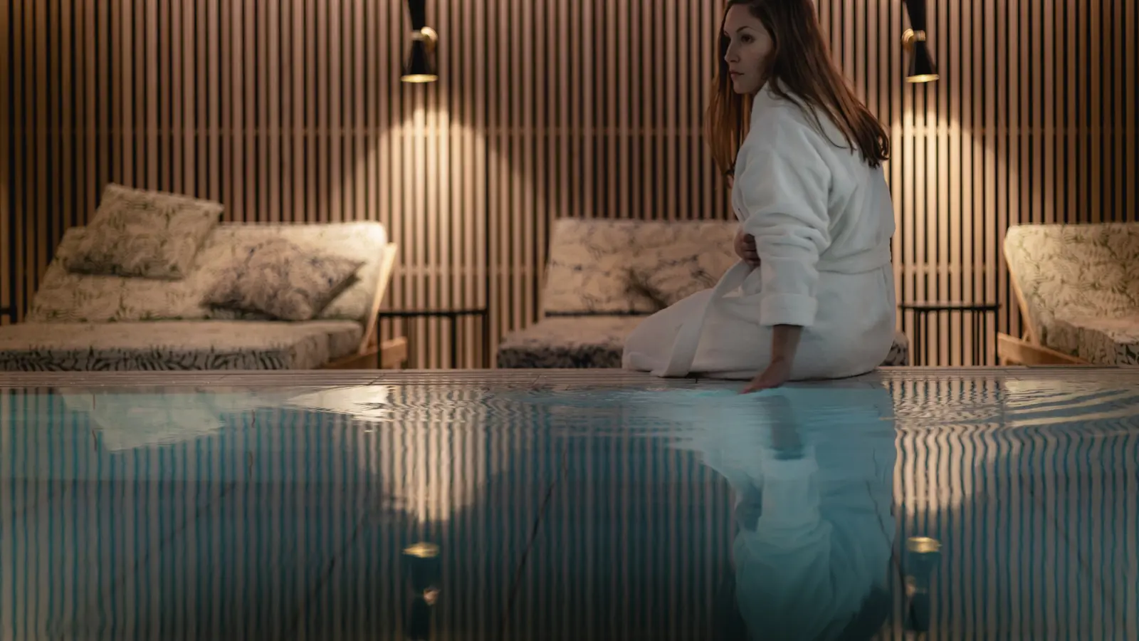 Woman sitting on the edge of a pool