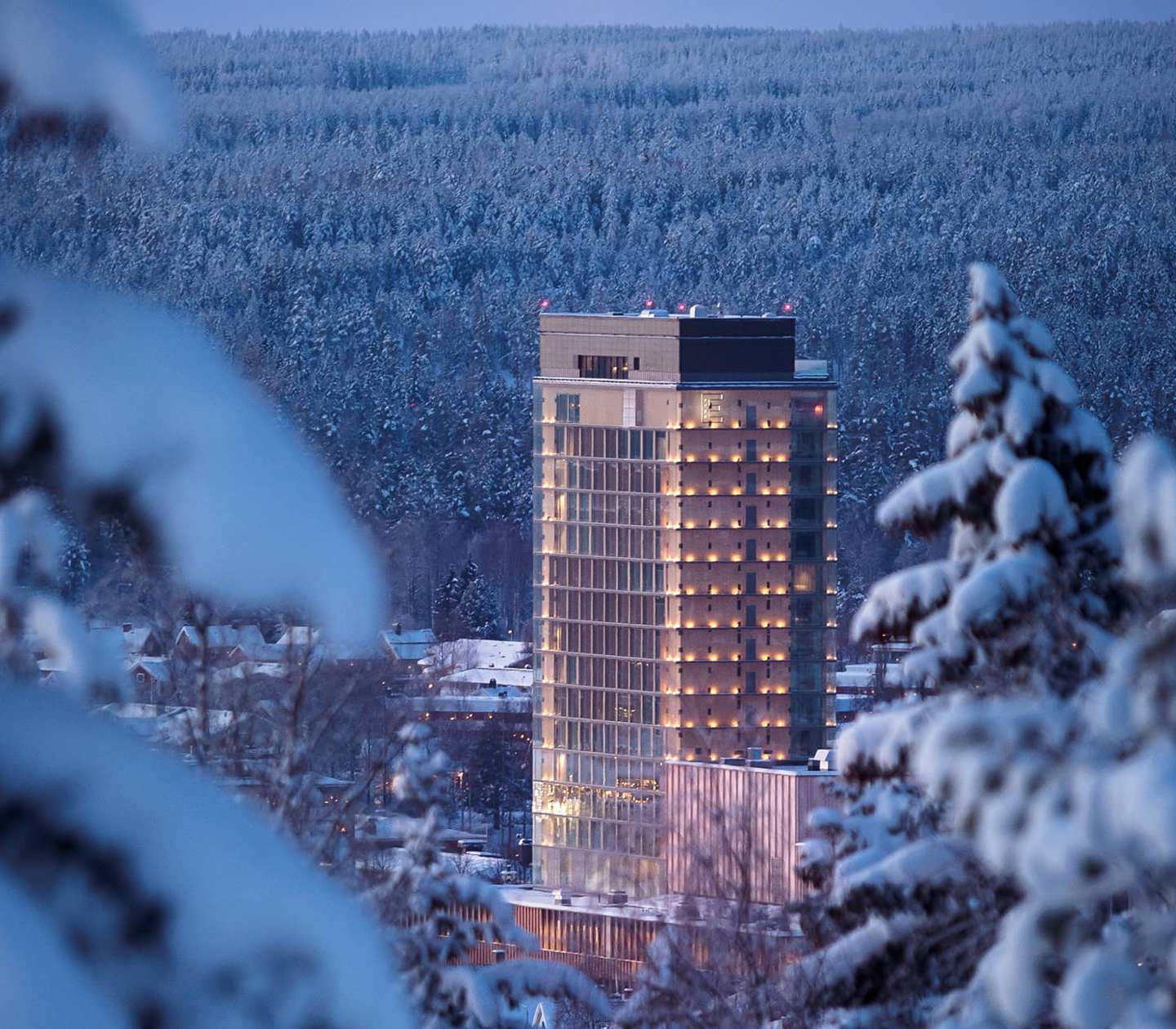 The 20-story Wood Hotel by Elite with snow-covered trees all around