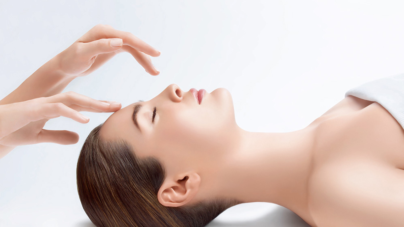 Woman with closed eyes getting a facial massage