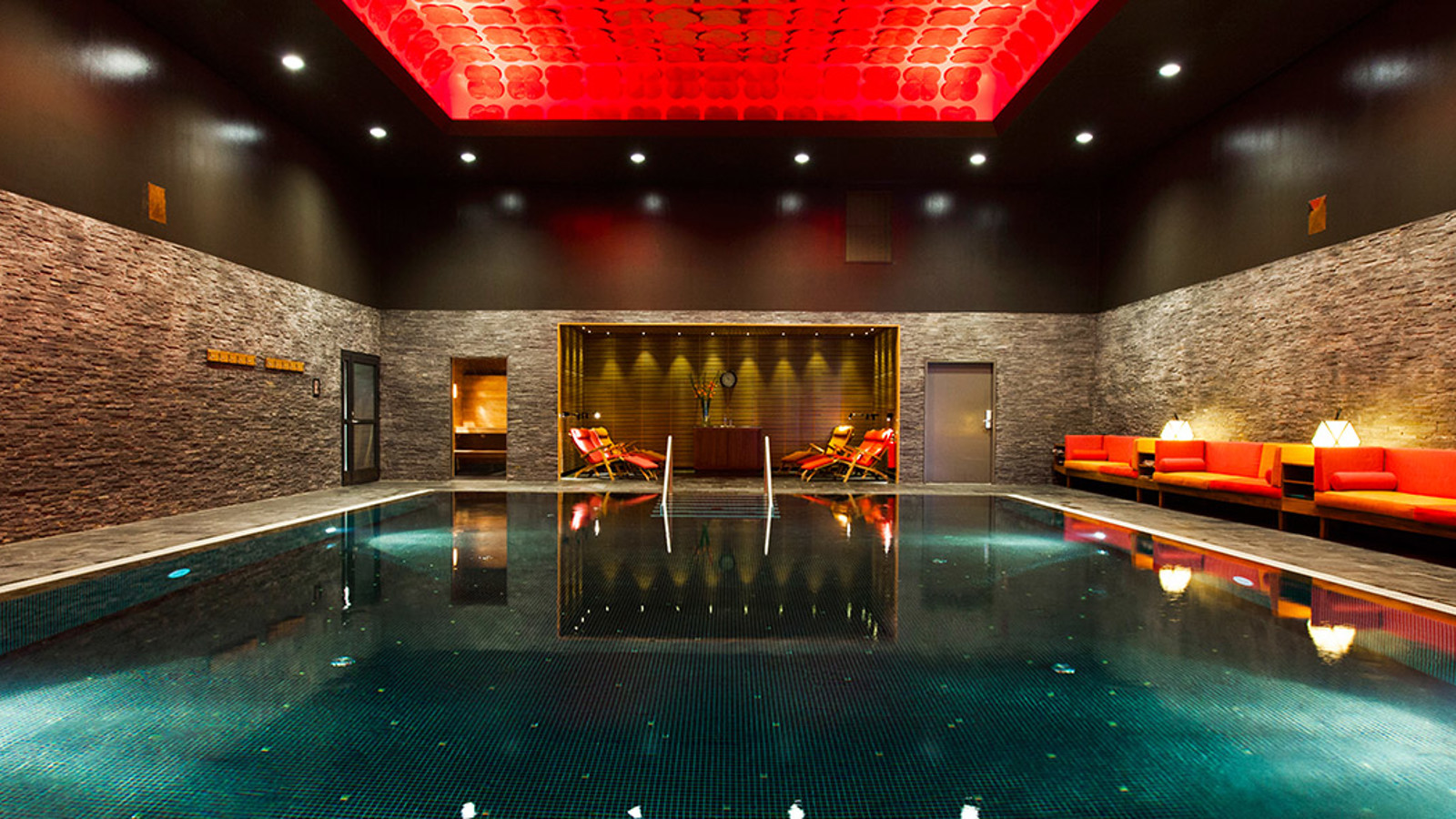 Indoor swimingpool with a red ceiling and turquoise water