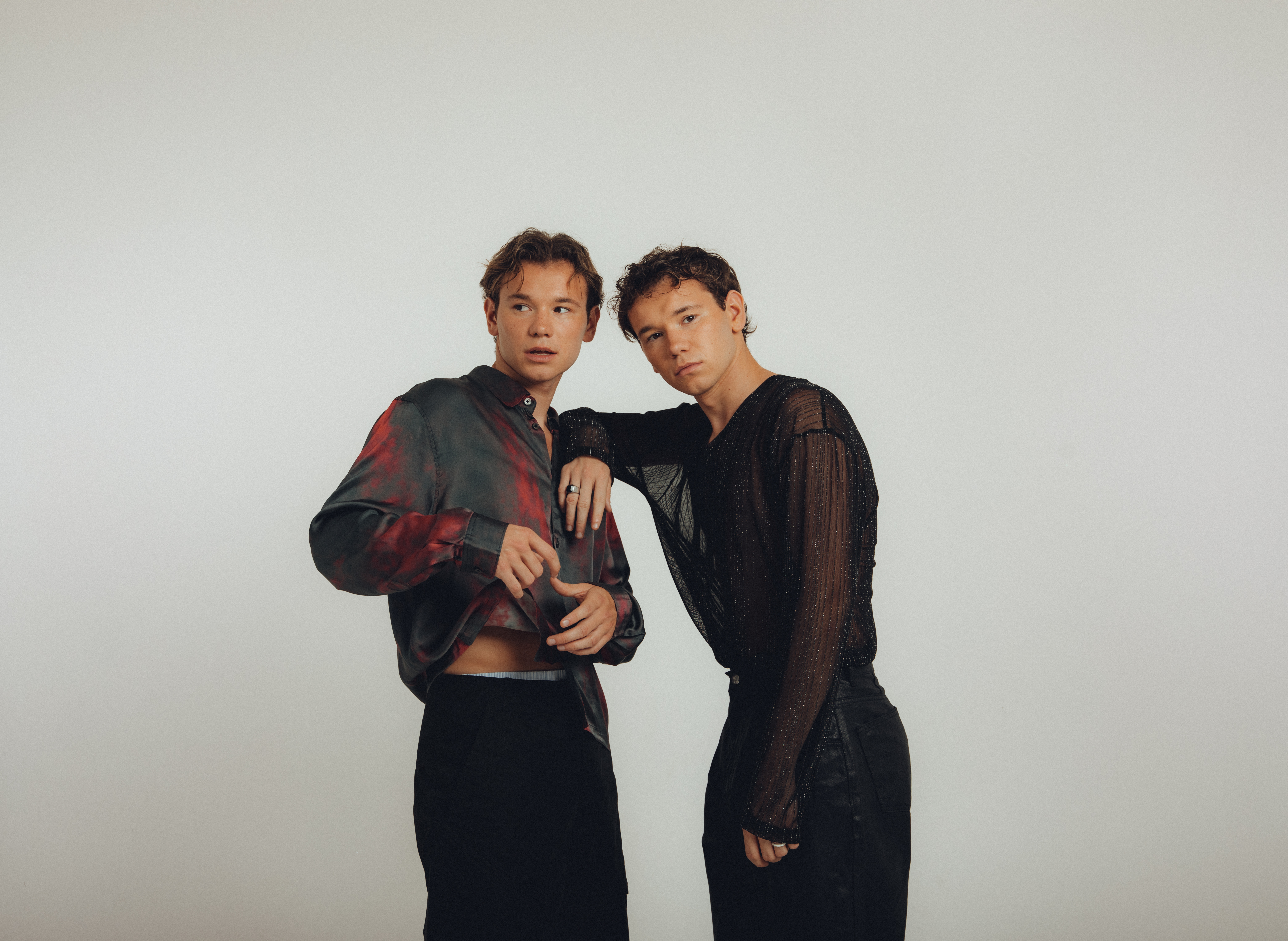 Two individuals in stylish black and red clothing