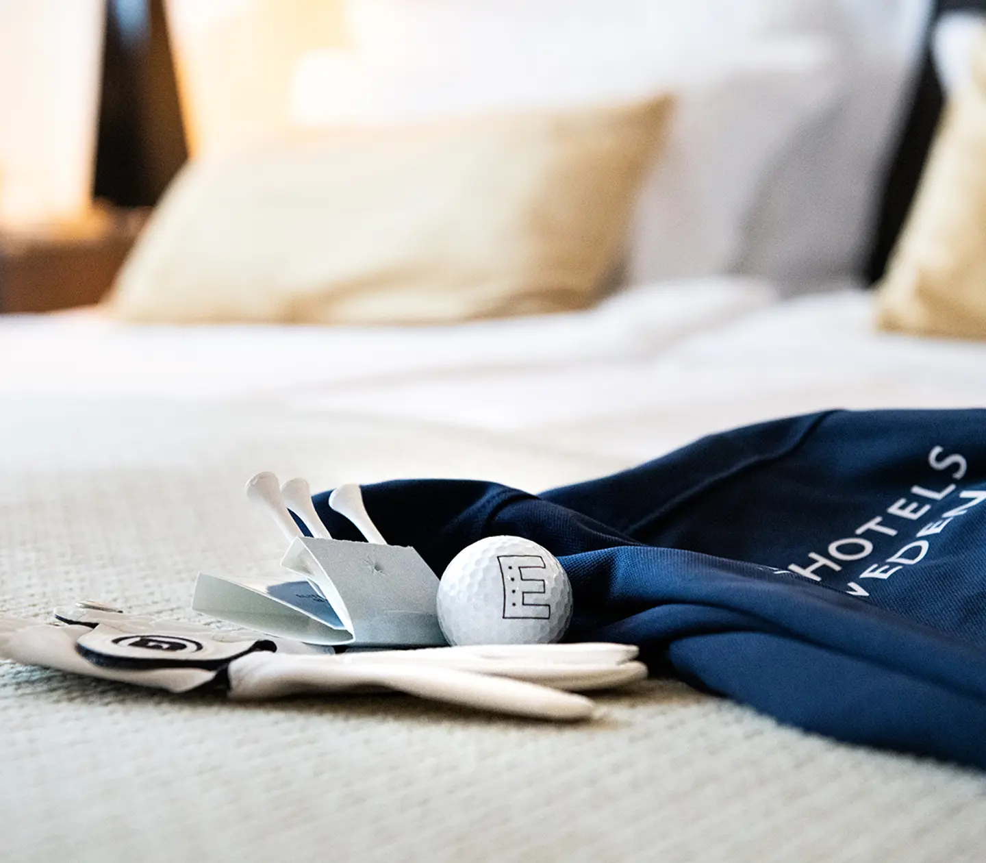 Golfutrustning liggandes på en säng
