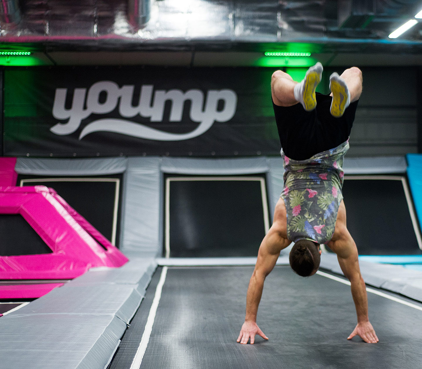 A person standing on hands on a trampoline