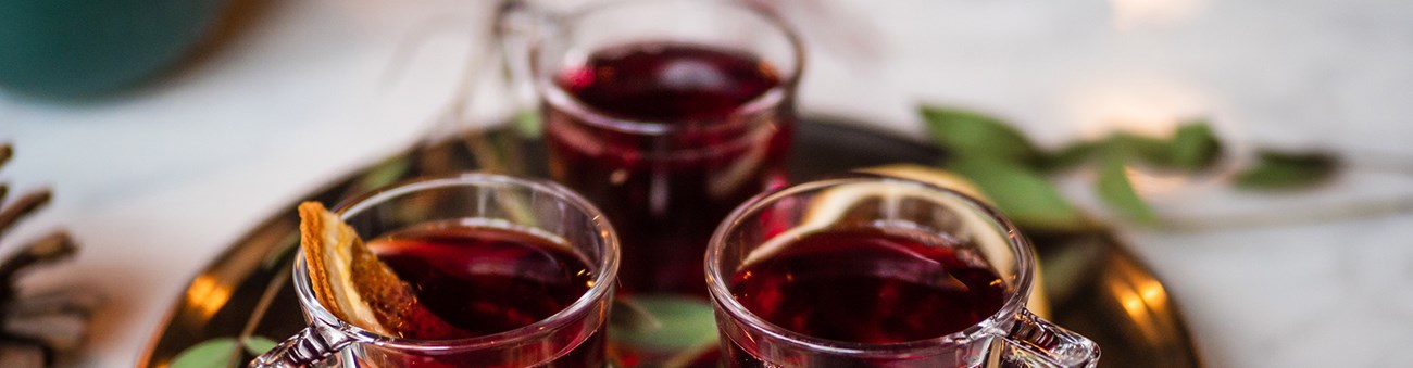 Tre muggar i glas med glögg