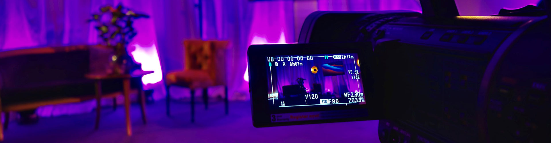 Studiomiljö med lila belysning och filmkamera