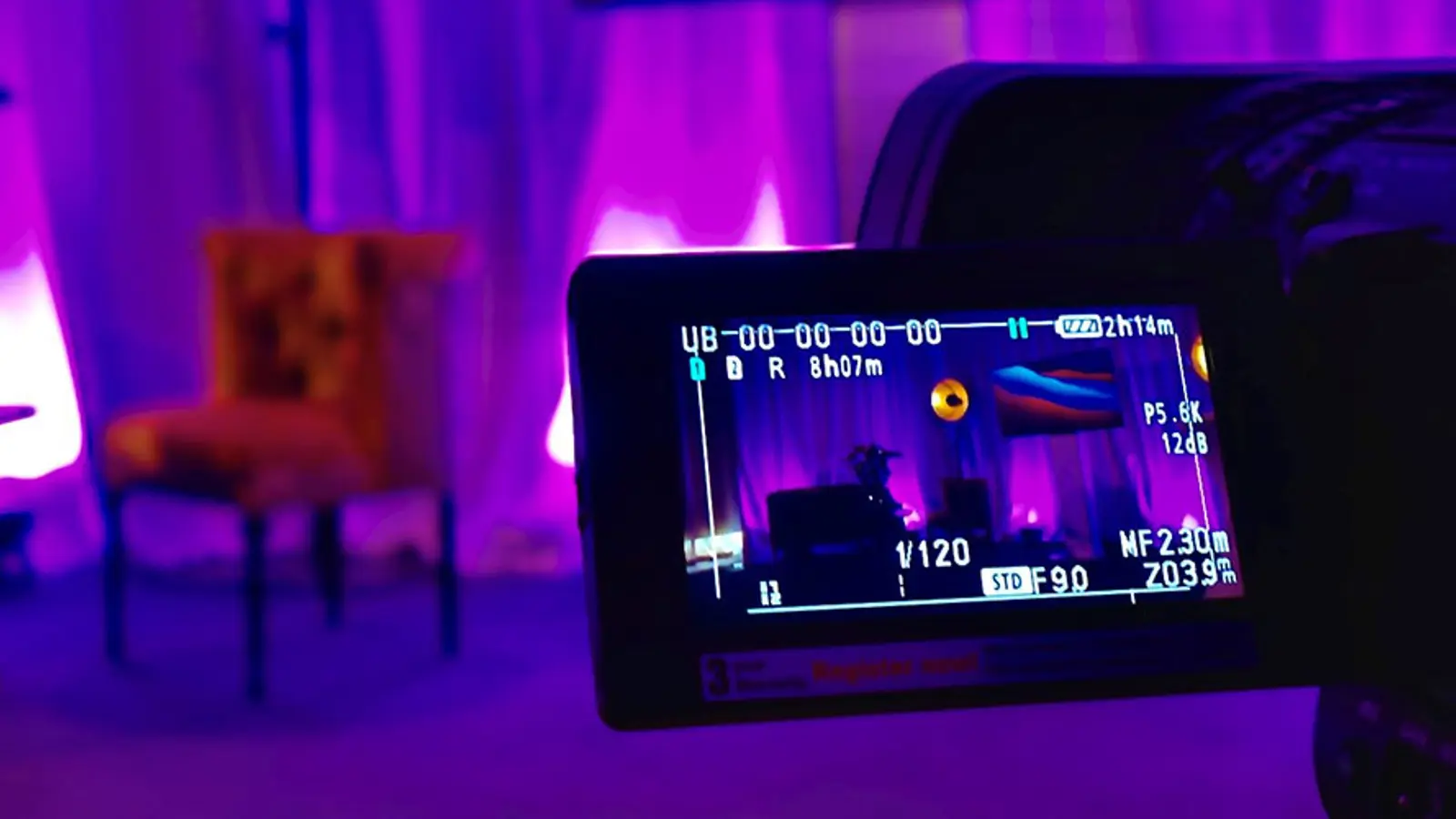 Studiomiljö med lila belysning och filmkamera