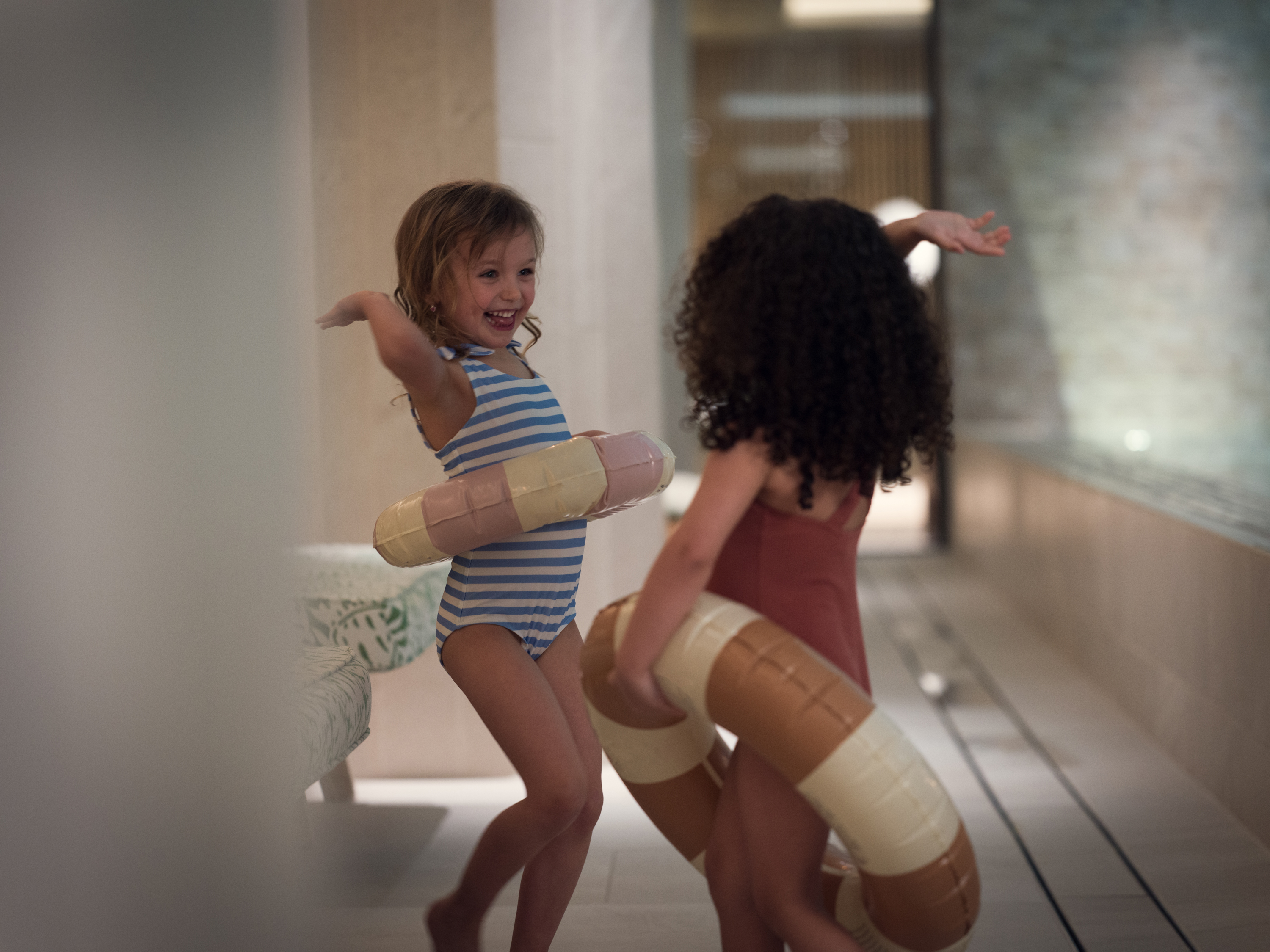 Barn med badringar vid kanten av en pool