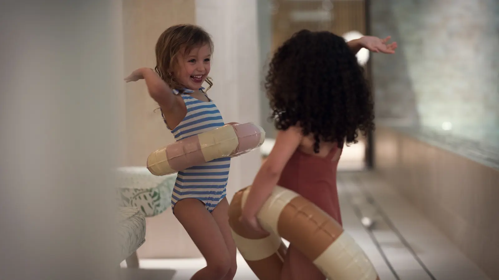 Barn med badringar vid kanten av en pool